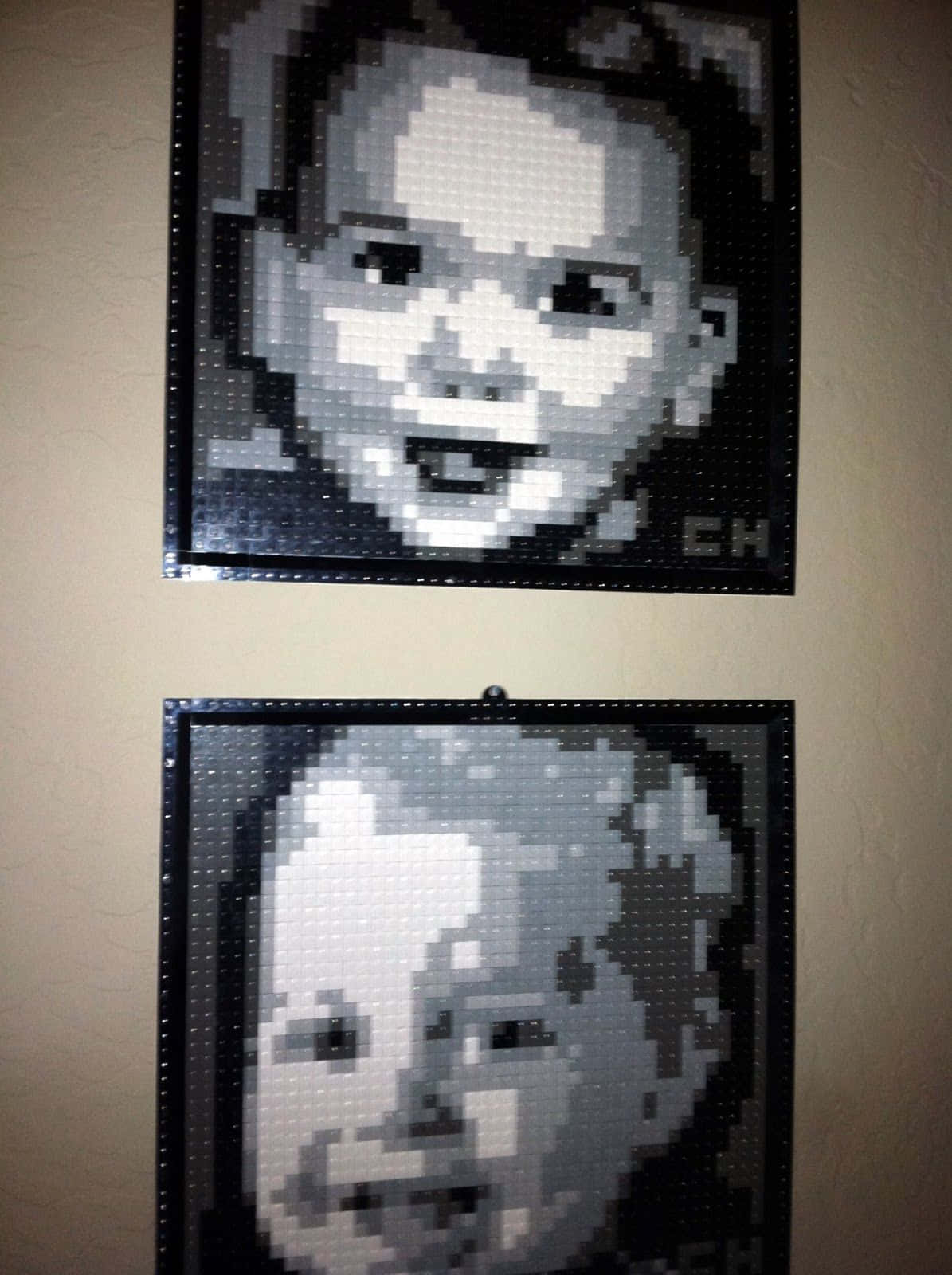 Lego Art 桌布 壁紙 — 兩幅微笑兒童的像素化LEGO肖像並排掛在米色牆上。