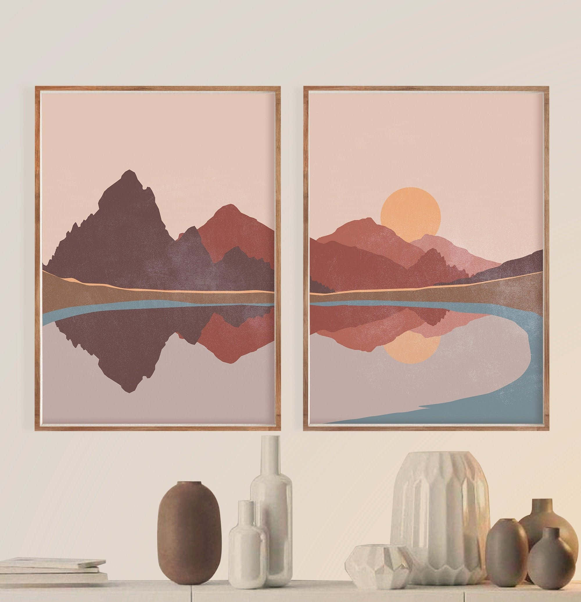 Modern Minimalist Art 桌布 壁紙 — 兩幅裱框的極簡主義山脈藝術印刷品，帶有粉紅色日落色調，懸掛在一個擺放陶瓷花瓶的架子上方。
