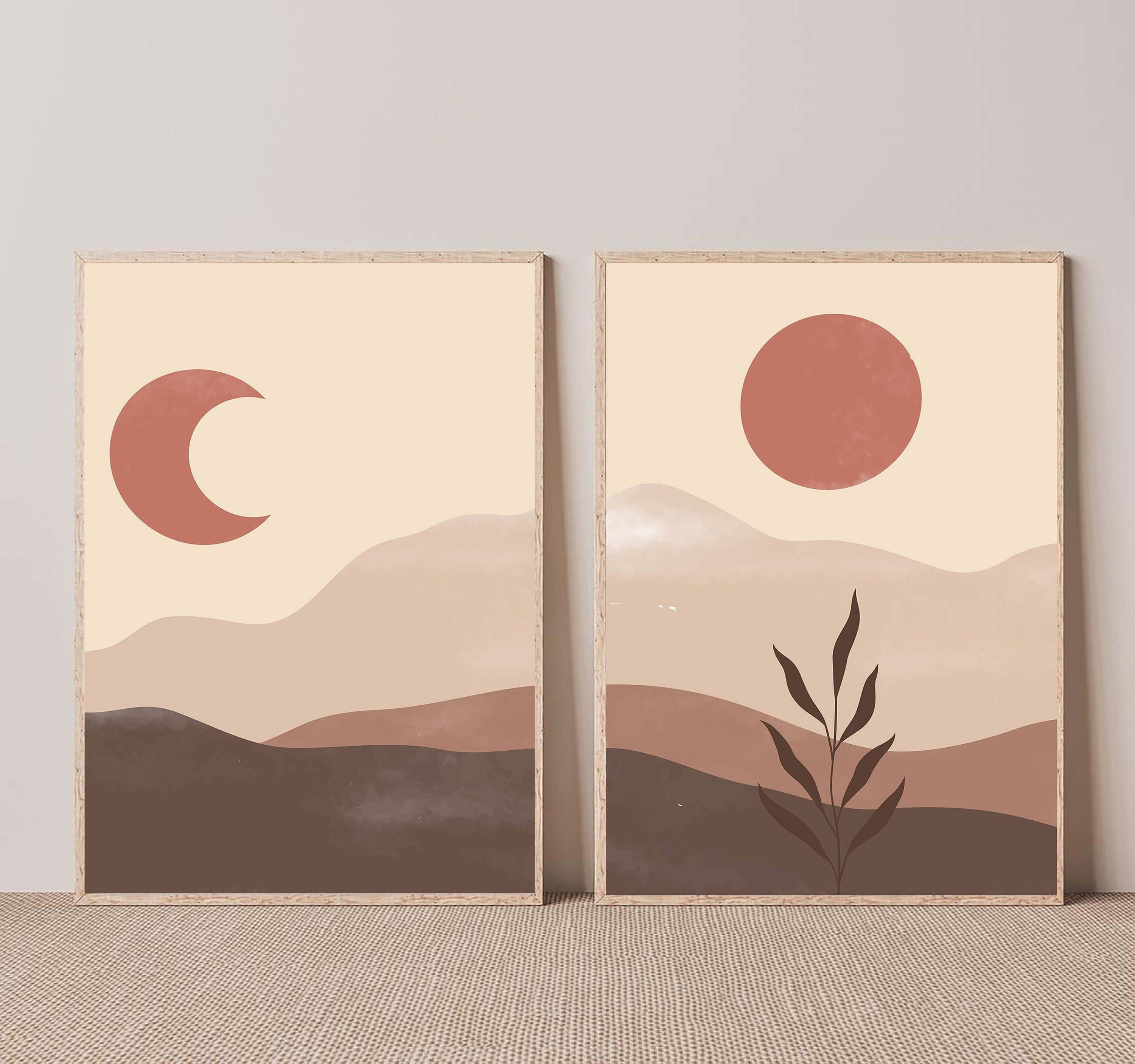 Minimalist Painting 桌布 壁紙 — 兩幅裱框的極簡沙漠藝術印刷品展示了一彎新月和太陽，下方是層疊的山丘，並有一株植物的剪影。