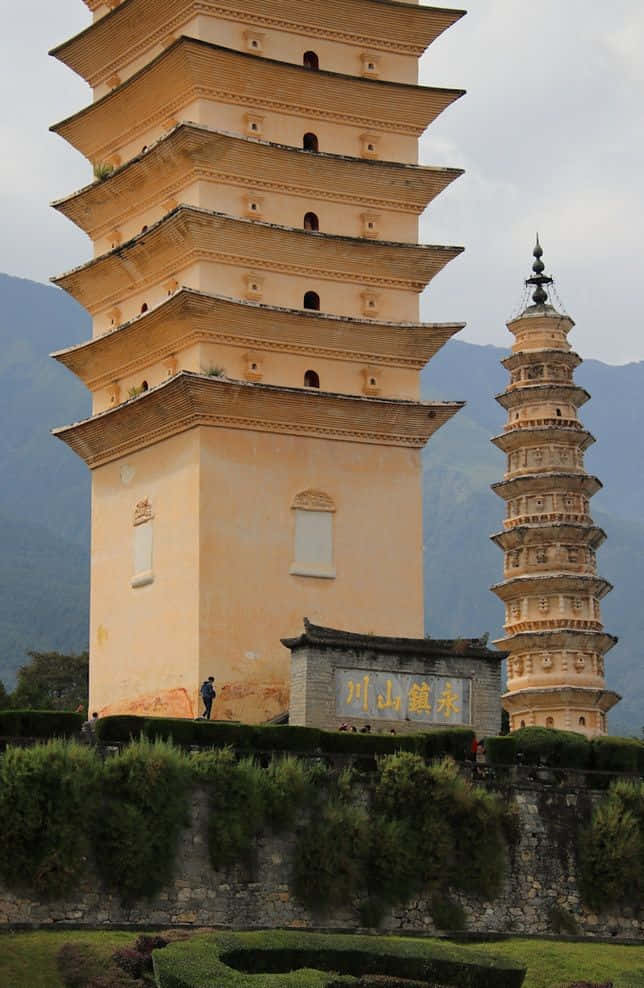 Building 桌布 壁紙 — 兩座古老的多層寶塔在陰天背景下，聳立在霧氣繚繞的山巒前。