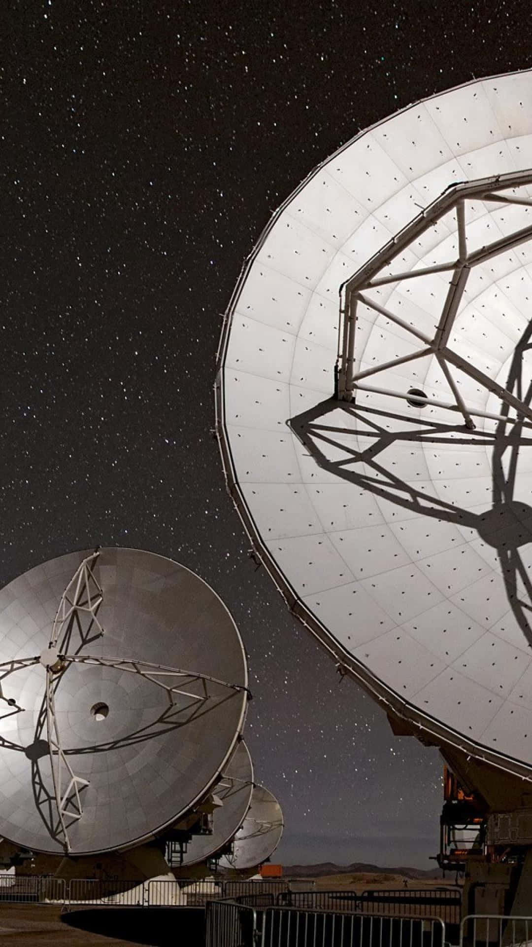 Radio Telescope 桌布 壁紙 — 兩座巨大的無線電望遠鏡矗立在星空下，在偏遠的沙漠天文台捕捉宇宙信號。
