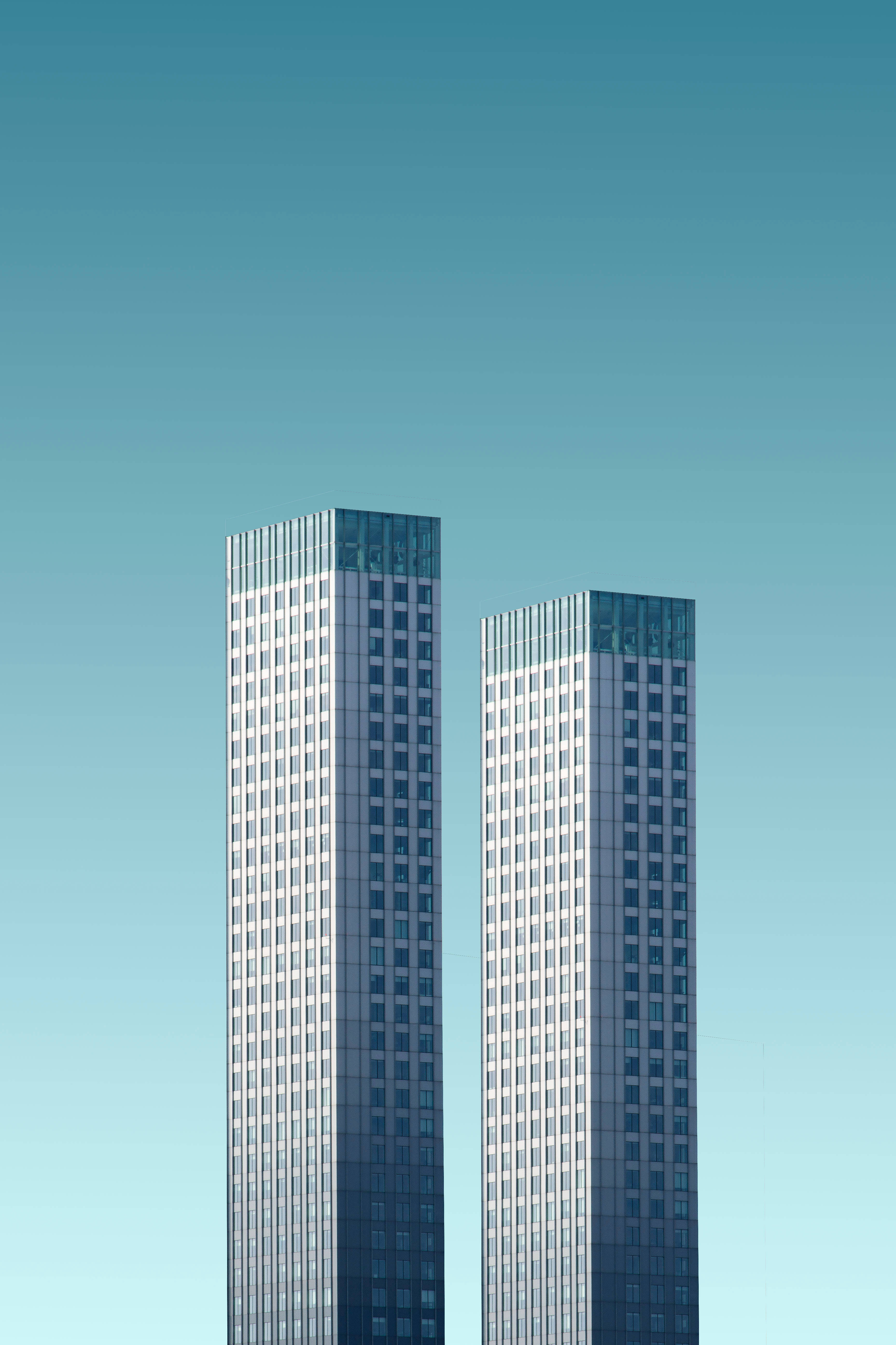 Skyscraper 桌布 壁紙 — 兩座時尚的玻璃摩天大樓在從青綠色到淡藍色的清晰漸變天空中升起。