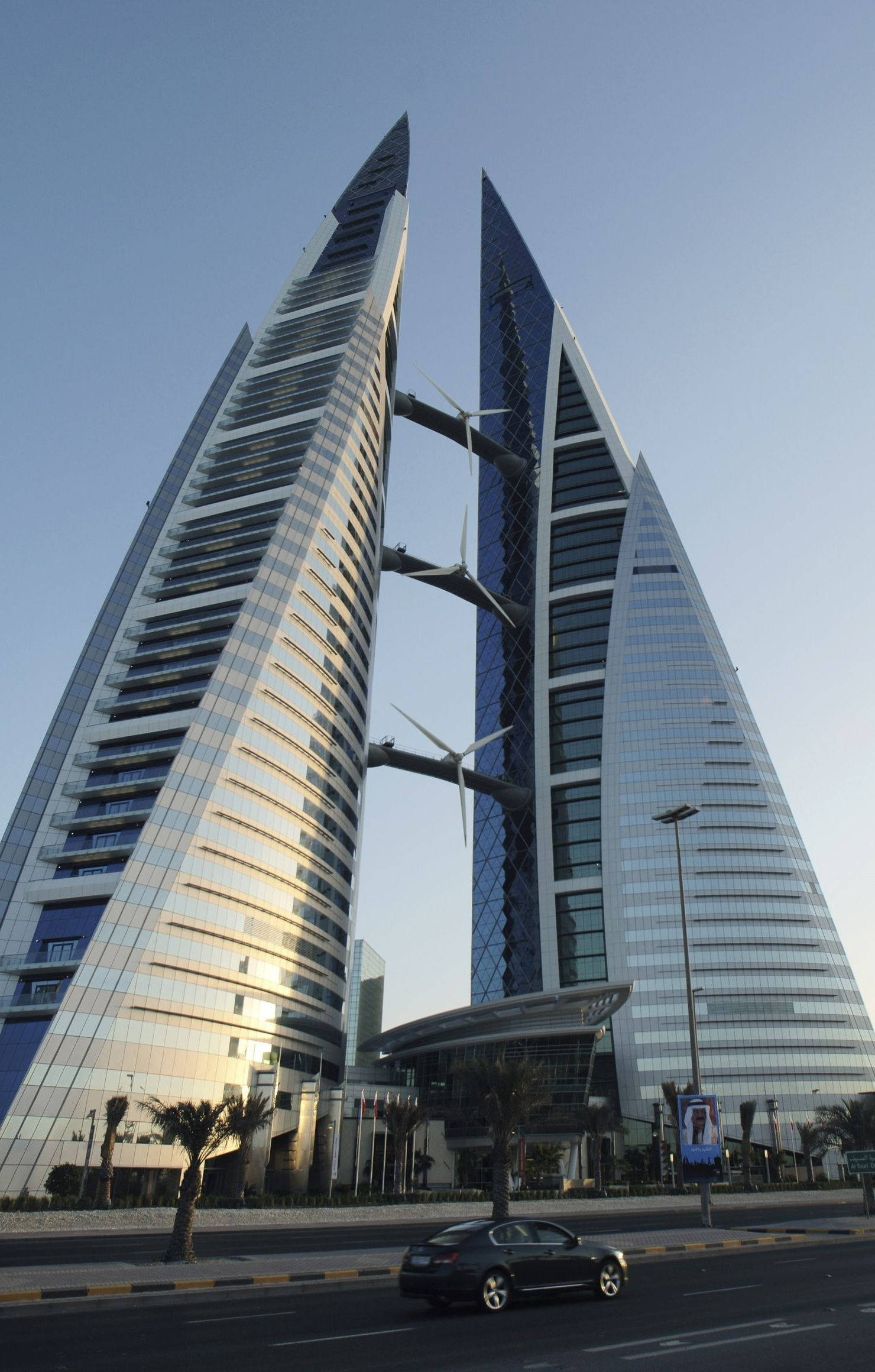 Bahrain 桌布 壁紙 — 兩座高聳的玻璃摩天大樓，由風力渦輪機連接，襯著清澈的藍天。