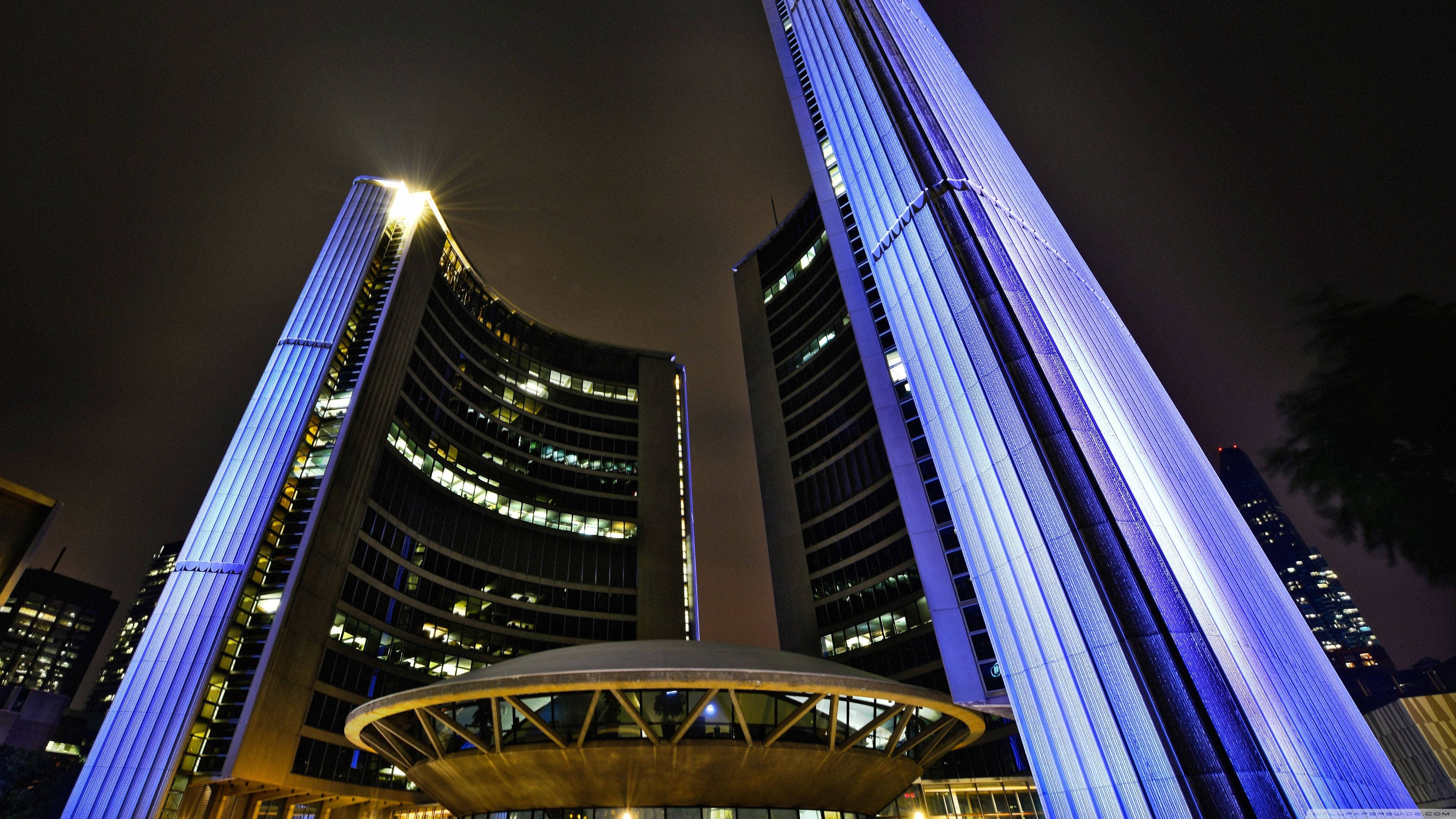Toronto 桌布 壁紙 — 兩座高聳的現代建築在黑暗的夜空中散發出鮮豔的藍光，構成城市天際線。