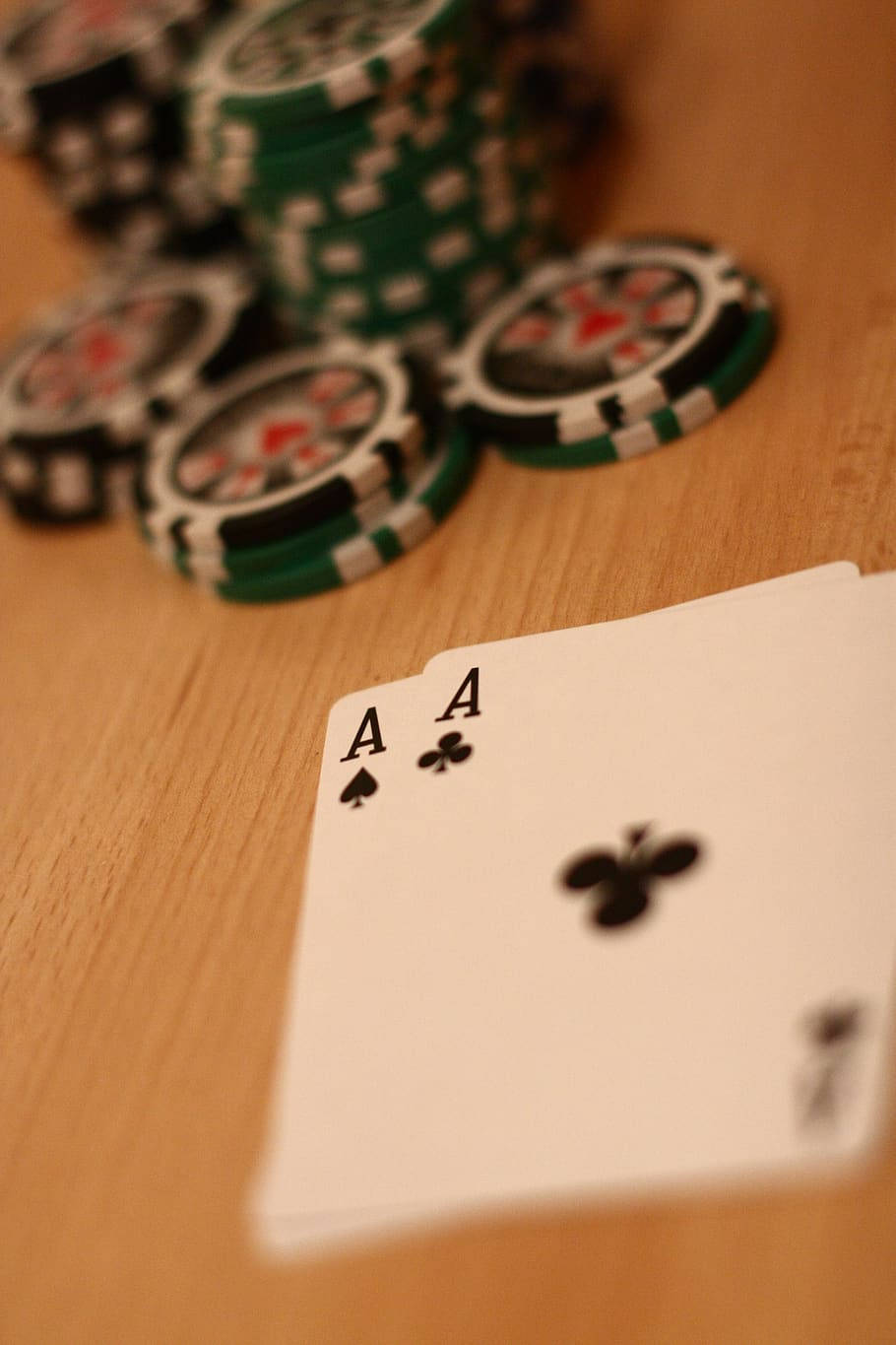Casino 桌布 壁紙 — 兩張Ace撲克牌放在木桌上，旁邊有綠色和黑色的籌碼堆。