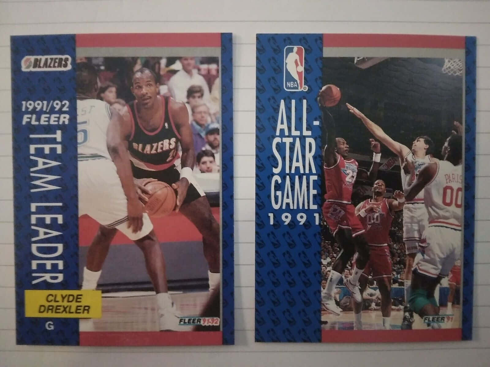 籃球 桌布 壁紙 — 兩張復古1991 92 Fleer NBA球星卡，展示克萊德·德雷克斯勒和全明星賽動作鏡頭，位於橫線紙上。