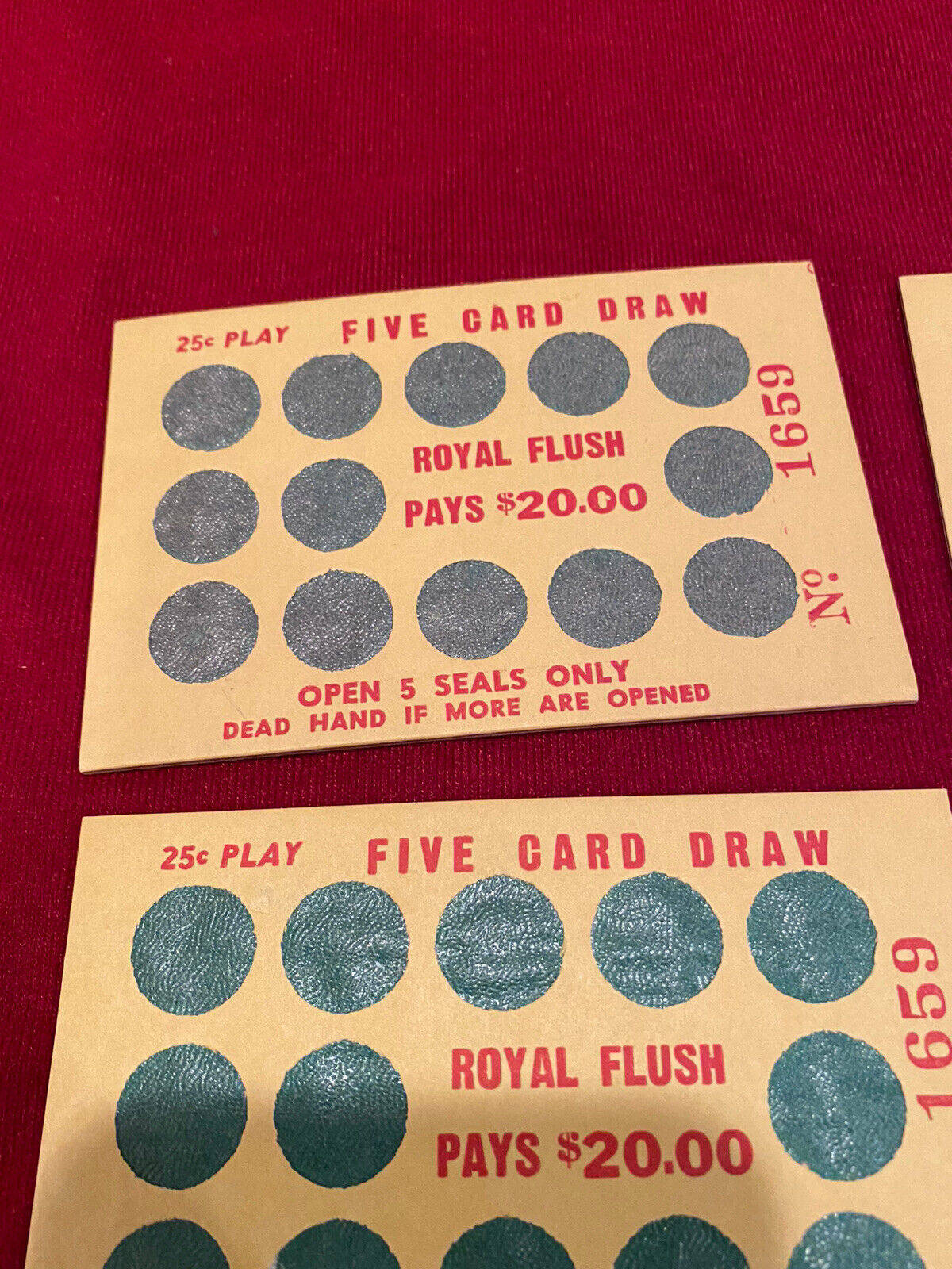 Poker 桌布 壁紙 — 兩張復古25美分五張抽牌撲克牌，帶有密封圓圈，放在深紅色布料表面上。