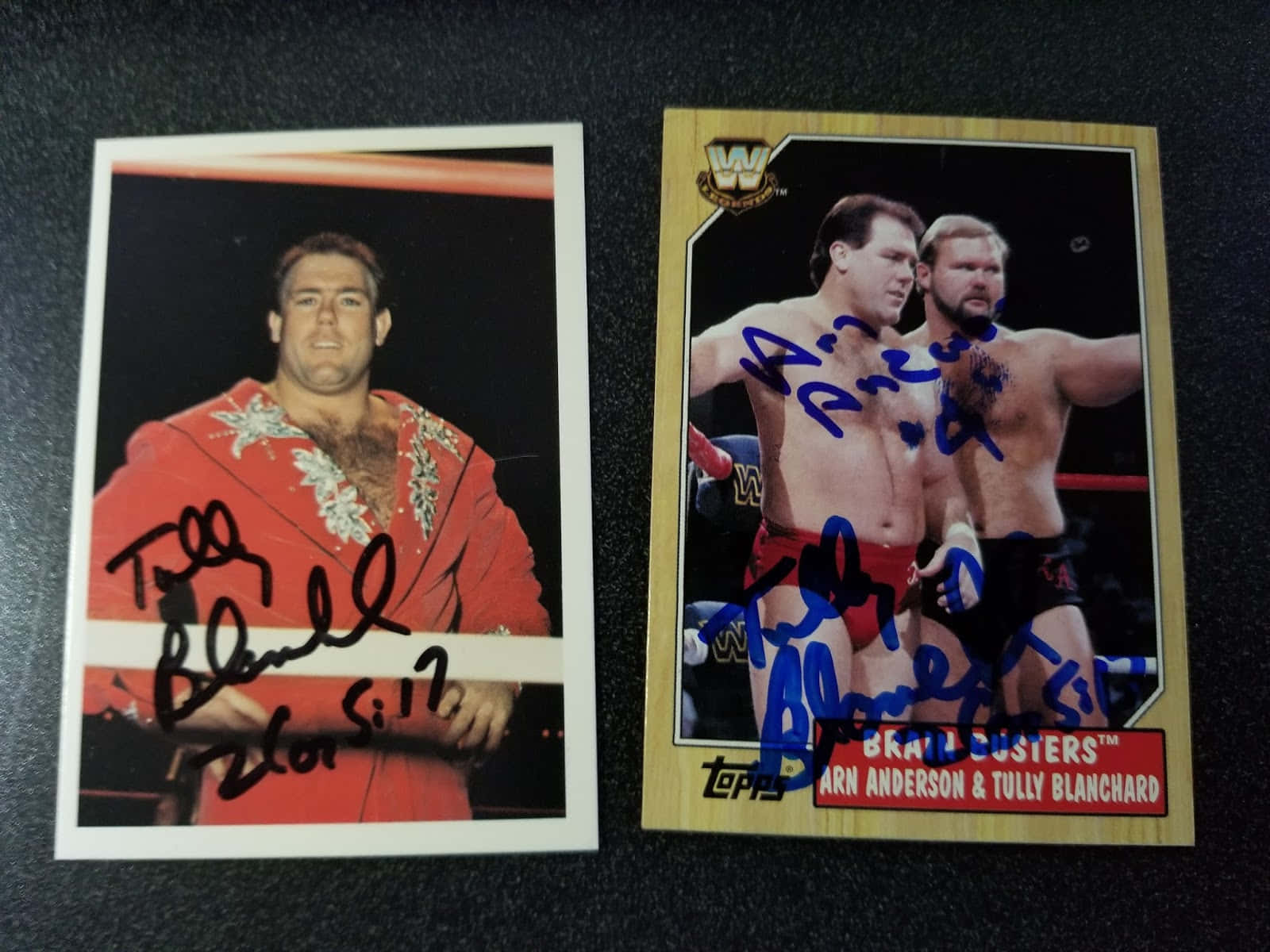 摔角 桌布 壁紙 — 兩張簽名WWE交易卡， featuring Tully Blanchard 和 Brain Busters 二人組，置於深色表面上。