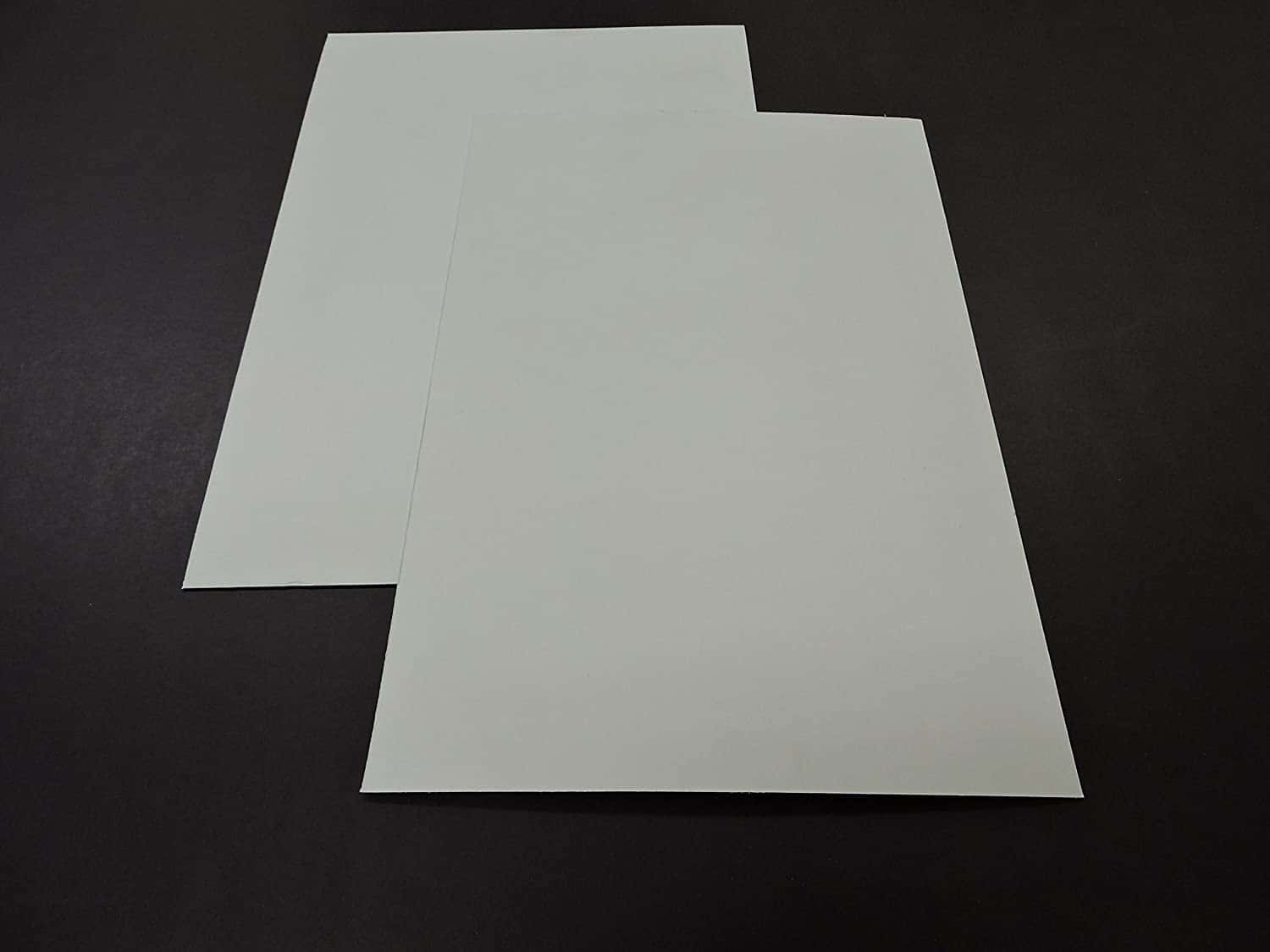 Poster Board 桌布 壁紙 — 兩張純白色矩形紙張放在帶有柔和陰影的深色紋理表面上。