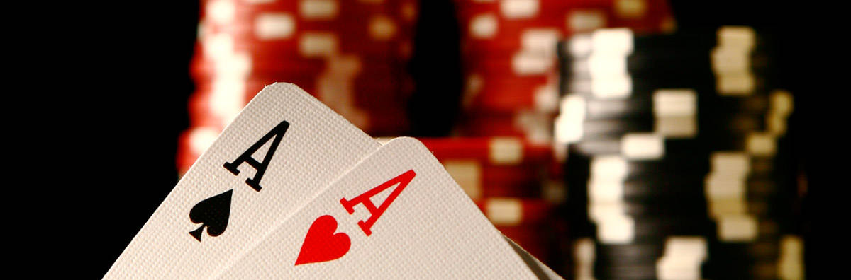 Playing Cards 桌布 壁紙 — 兩張黑桃A和紅心A清晰對焦，置於模糊的紅色和黑色籌碼堆前。