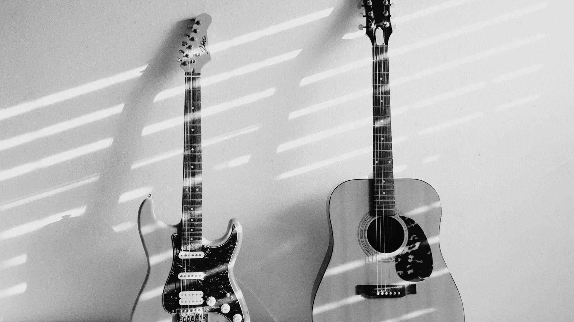 Black And White Guitar 桌布 壁紙 — 兩把吉他靠牆而立，沐浴在強烈條紋陽光下，投射出戲劇性的陰影。
