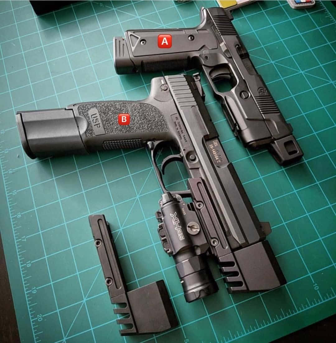 guns 桌布 壁紙 — 兩把黑色手槍配備戰術配件，放在帶有測量標記的綠色切割墊上。