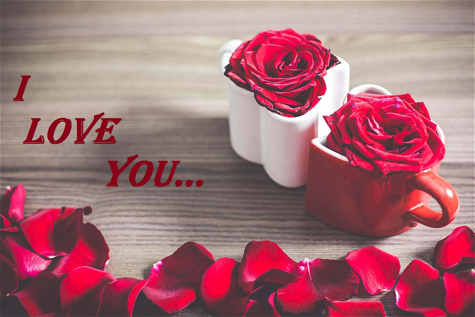 我愛你 桌布 壁紙 — 兩朵紅玫瑰在馬克杯中，散落花瓣和「I LOVE YOU...」文字在木質表面上。