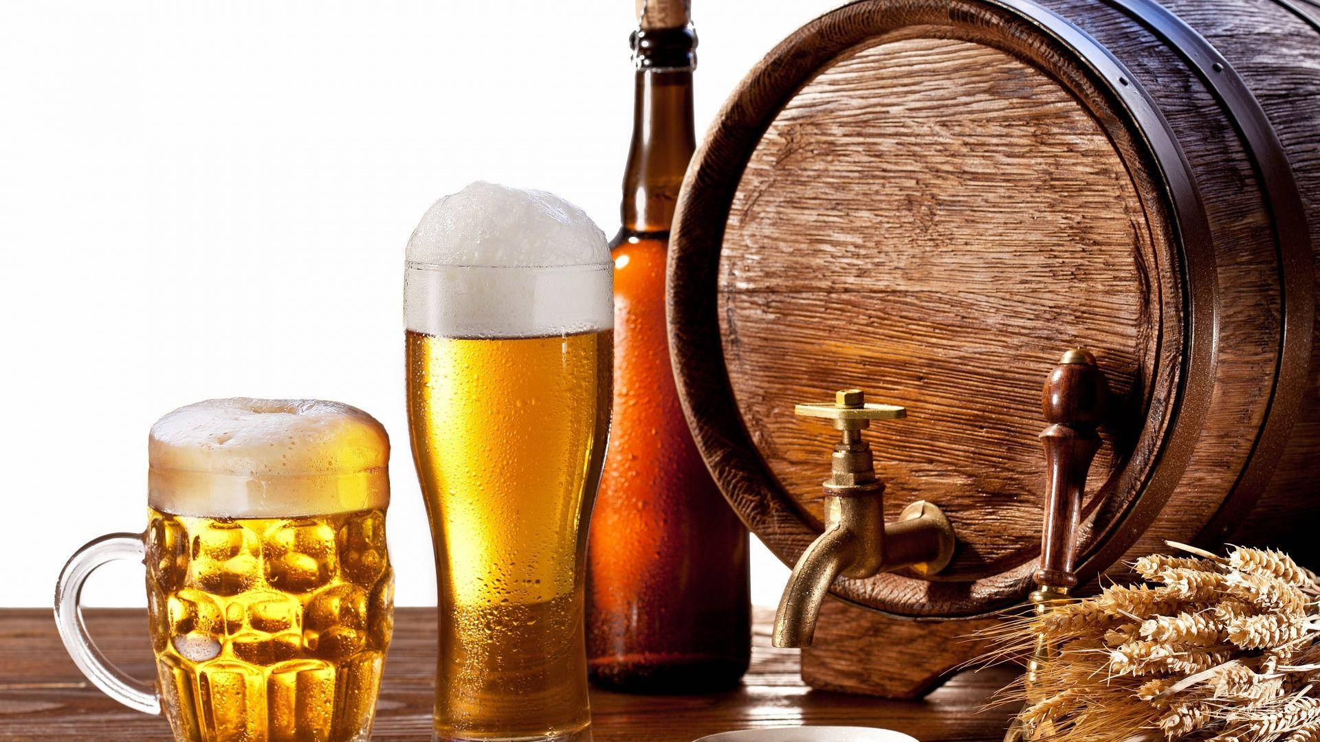 Beer 桌布 壁紙 — 兩杯泡沫啤酒、一個酒瓶和一個帶有小麥稈的木桶，放在質樸的桌子上。