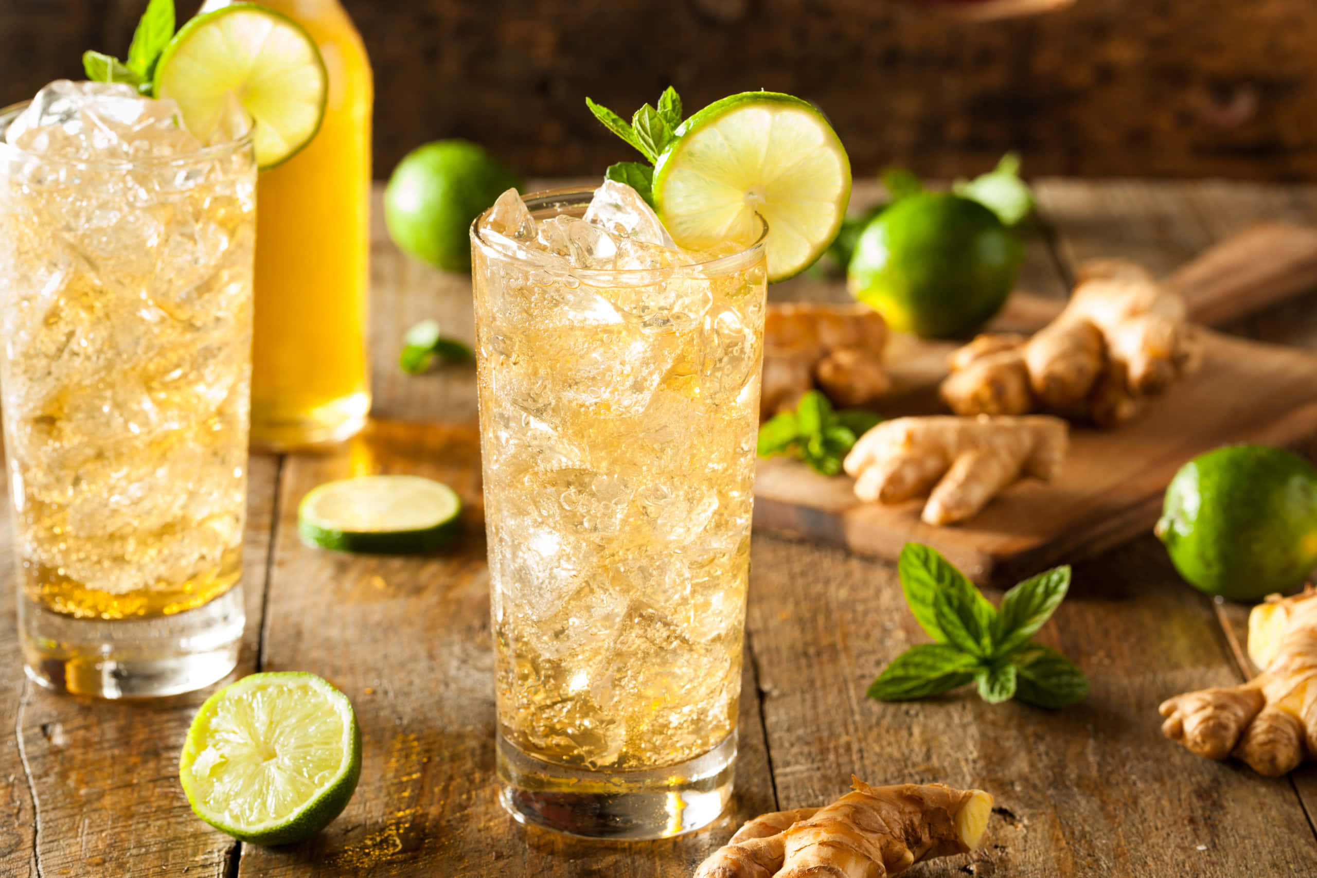 Lime 桌布 壁紙 — 兩杯清涼的薑青檸飲品加冰，飾以薄荷葉和青檸片，放在鋪滿新鮮食材的鄉村風木桌上。