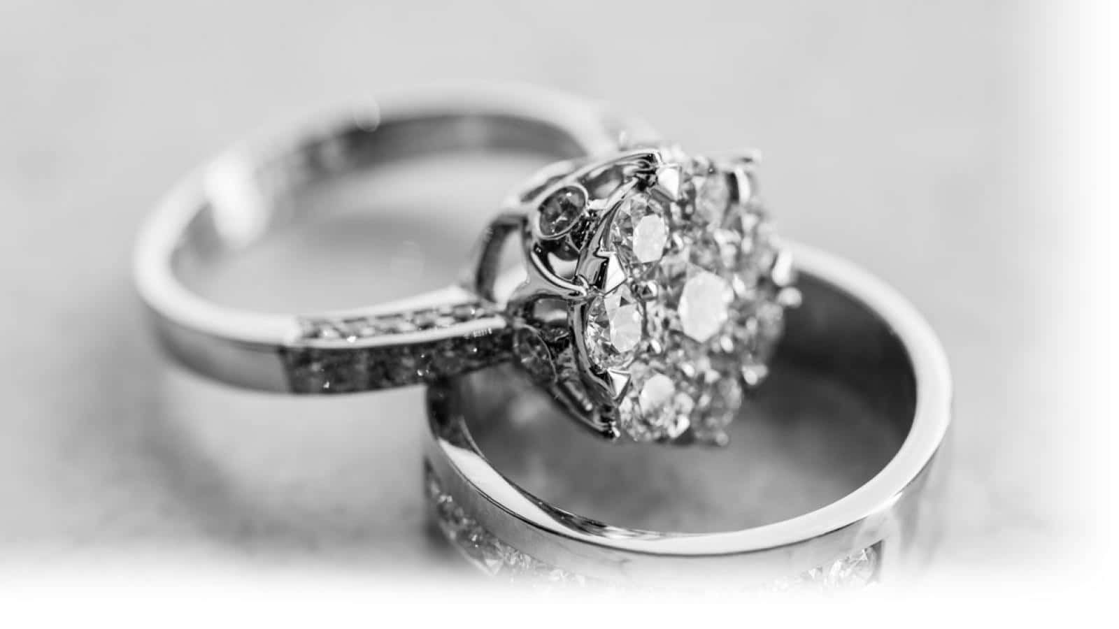 Ring 桌布 壁紙 — 兩枚優雅的結婚戒指在單色特寫中交織，背景柔和散景。