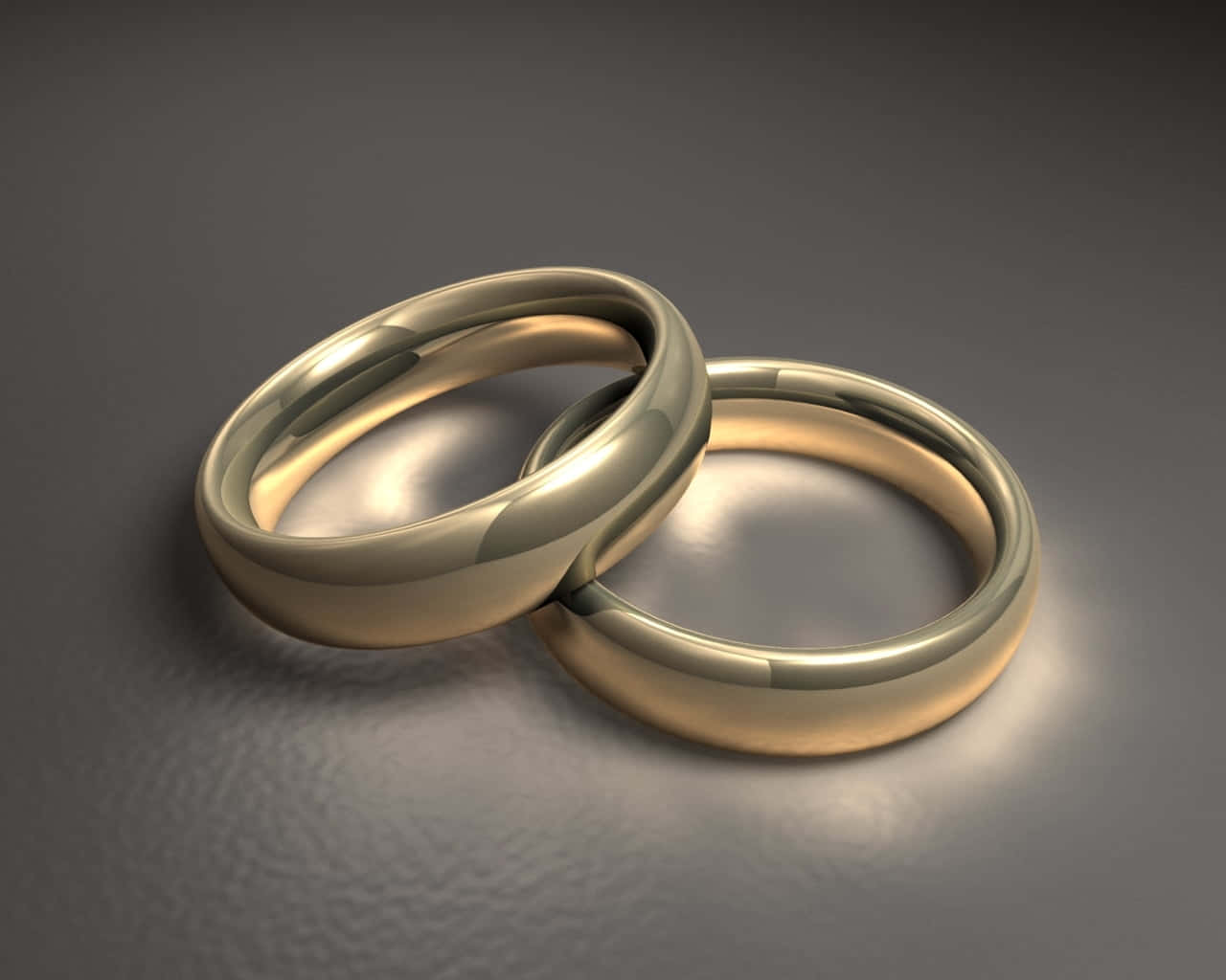 Wedding Rings 桌布 壁紙 — 兩枚拋光金質結婚戒指在柔和的攝影棚燈光下交織於有紋理的灰色表面上。