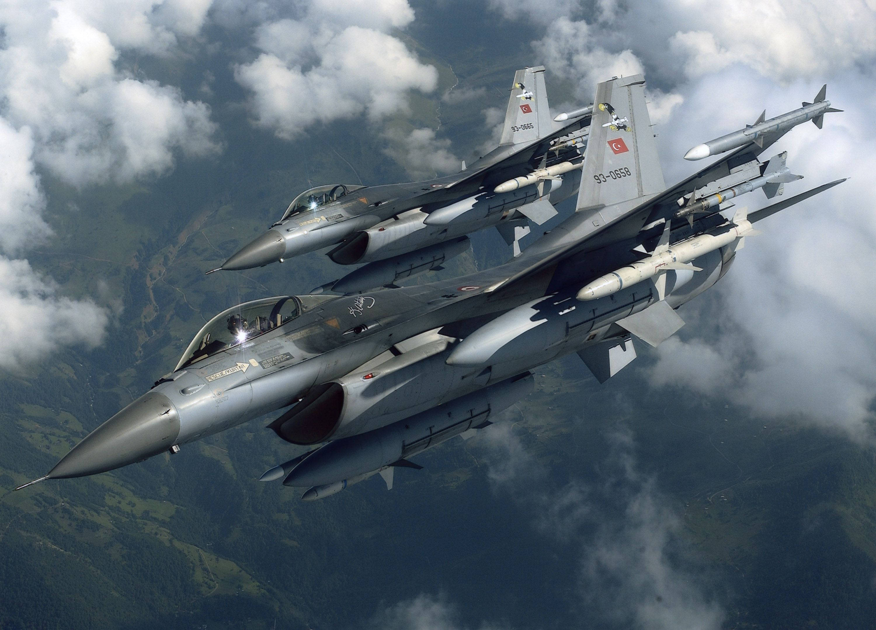 軍事動圖 桌布 壁紙 — 兩架土耳其F-16戰機在雲霧繚繞的山區上空緊密編隊飛行。