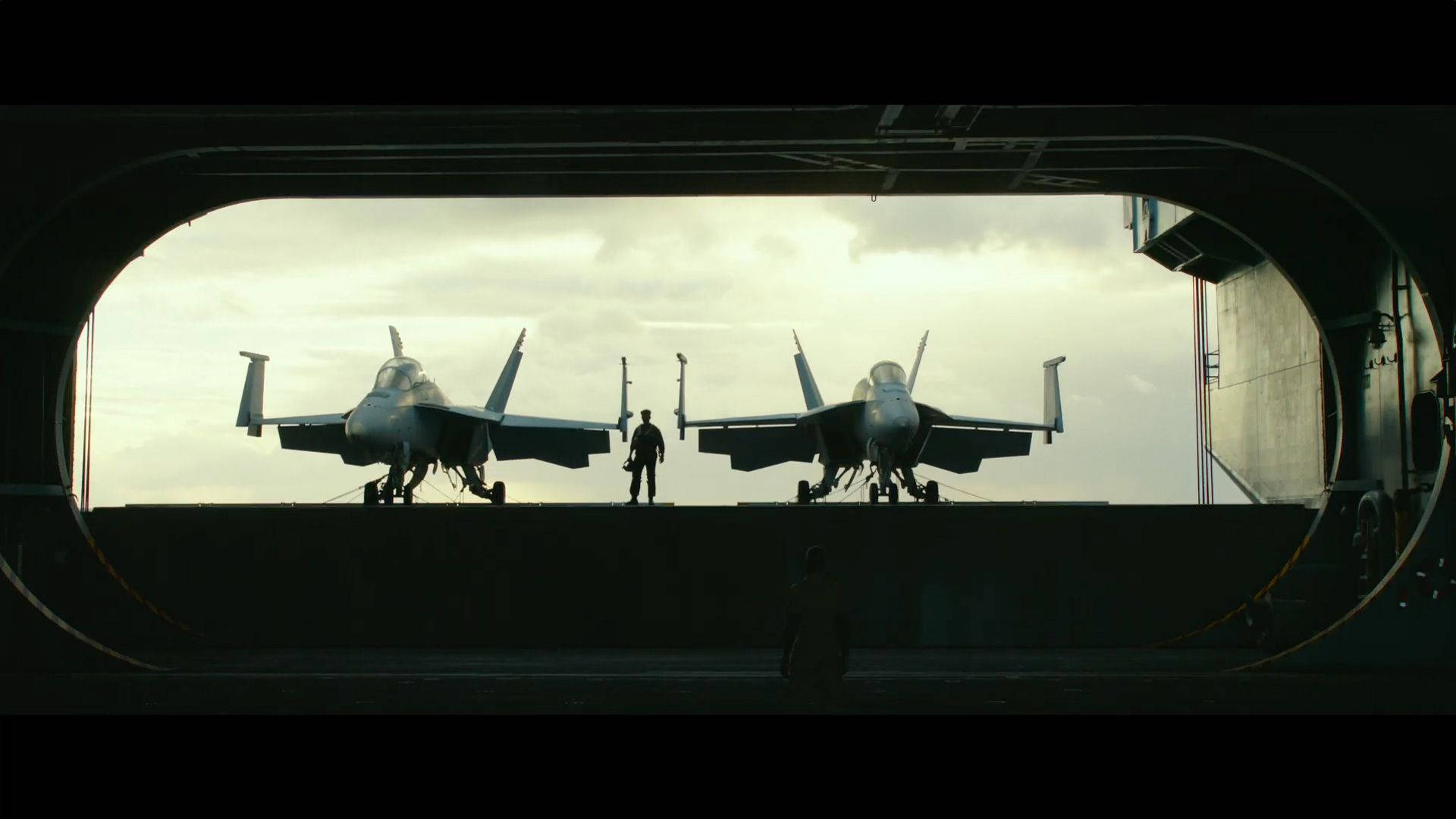 航空母艦甲板上的兩架戰鬥機，一名機組人員在它們之間走過。 — 捍衛戰士：獨行俠 壁紙