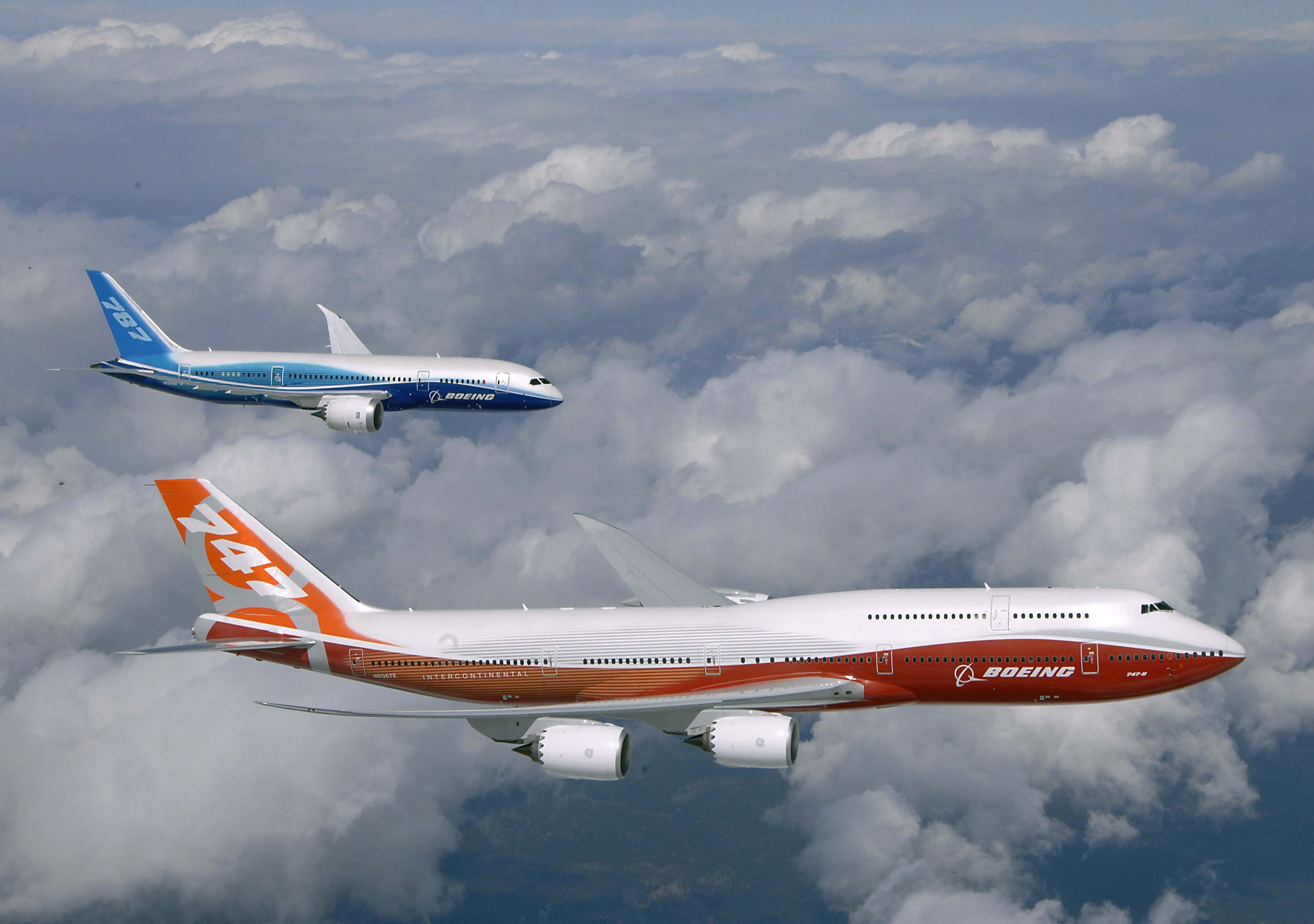 747 Airplane 桌布 壁紙 — 兩架波音飛機翱翔於蓬鬆的白雲之上，藍天隱約可見。