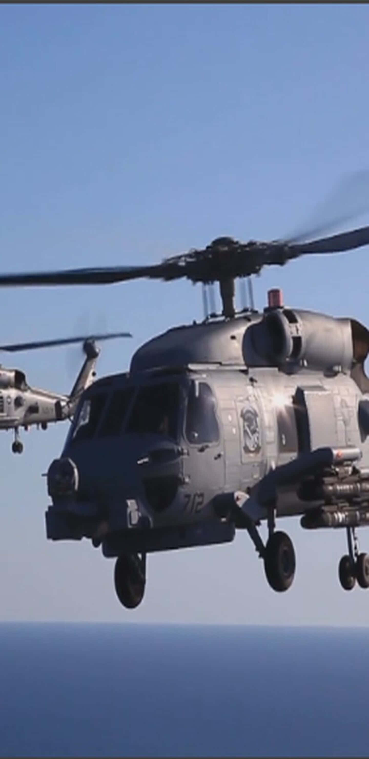 Helicopter 桌布 壁紙 — 兩架灰色軍用直升機在晴朗天空下低飛過平靜的藍色海洋。
