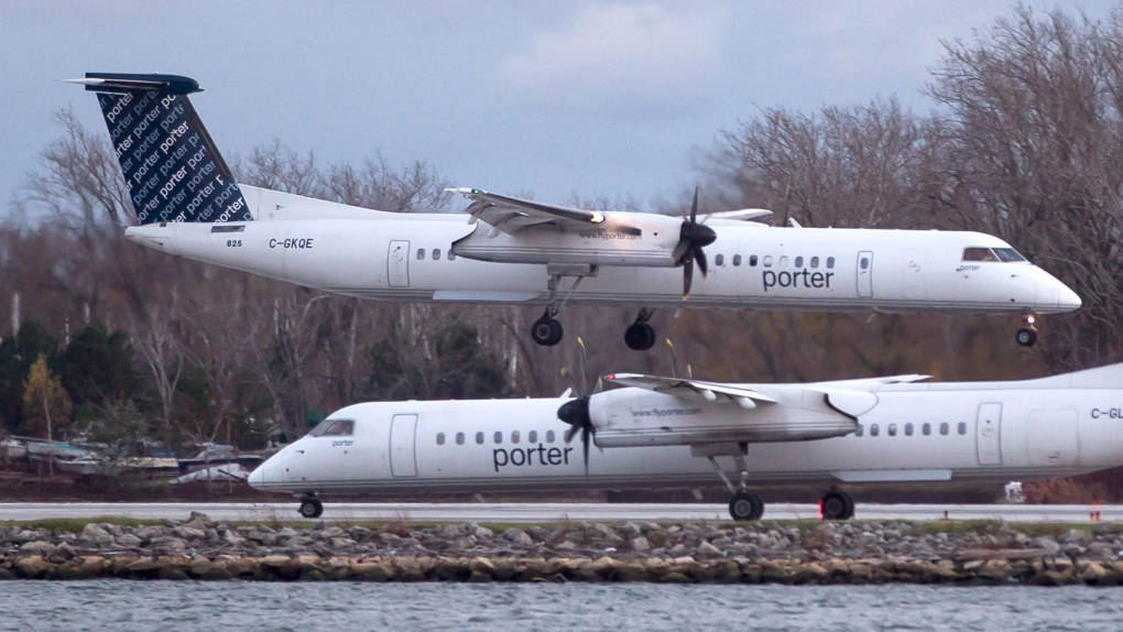  壁紙 — 兩架白色Porter Airlines渦輪螺旋槳飛機，一架在另一架上方起飛，附近有水，背景有光禿的樹木。