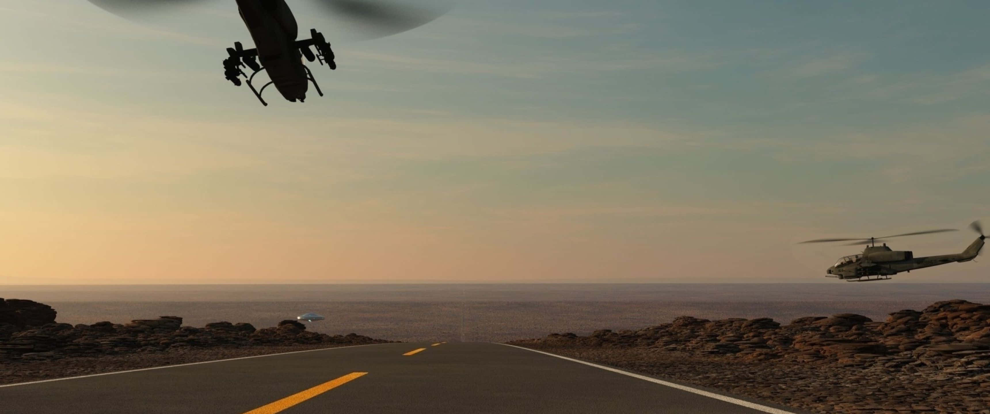 3440x1440p Helicopters 桌布 壁紙 — 兩架直升機在日落時分飛越荒涼的沙漠公路，在岩石地形上投下長長的陰影。