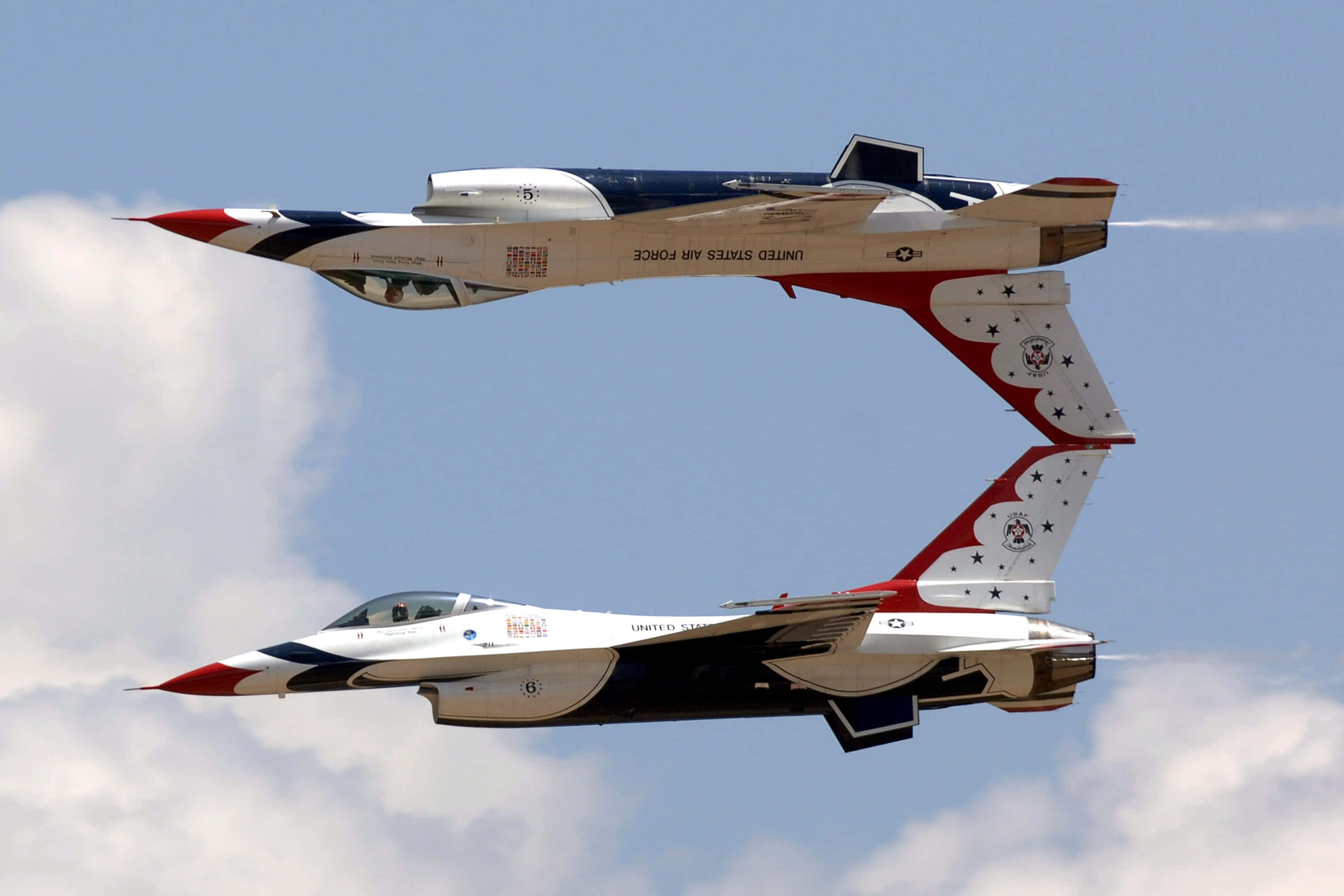 Air Force 桌布 壁紙 — 兩架美國空軍雷鳥噴射機在晴朗藍天和零星雲朵中緊密編隊飛行。