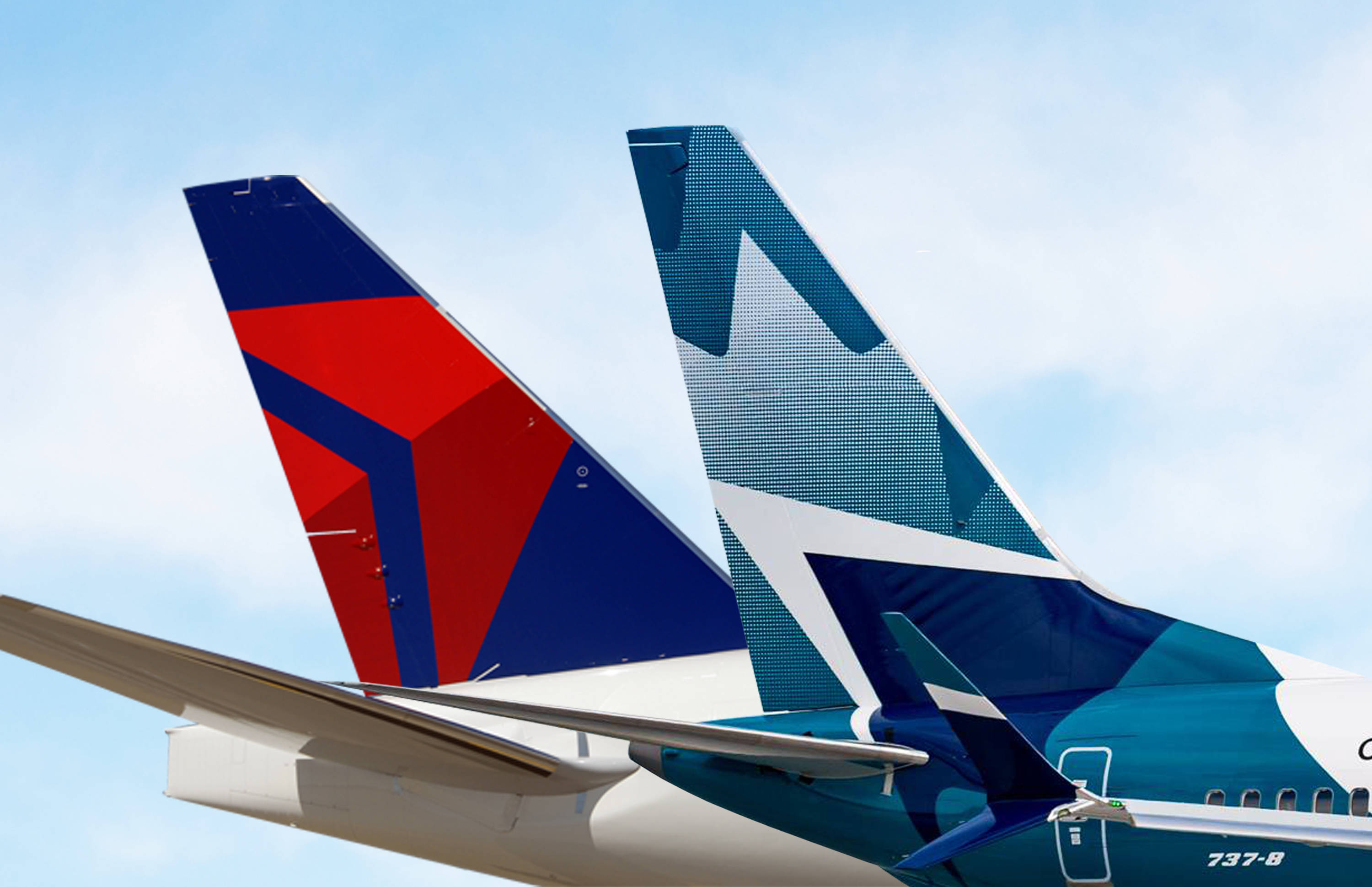 Plane 桌布 壁紙 — 兩架航空公司飛機的尾部，帶有鮮明的紅色、藍色和藍綠色塗裝，並排停放在藍天白雲下。