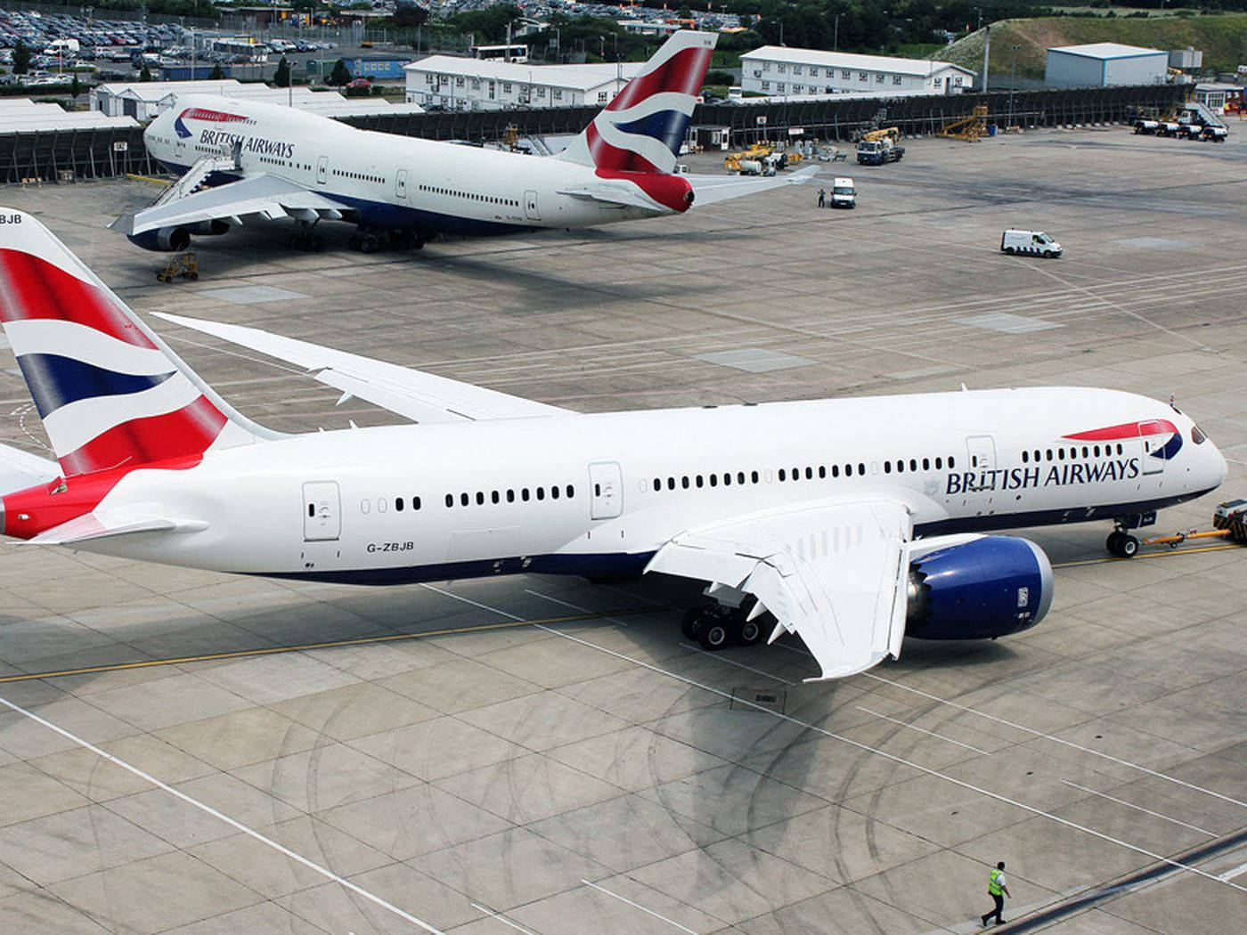 Airport 桌布 壁紙 — 兩架英國航空飛機停泊在陽光明媚的機場停機坪上，附近有地勤人員和車輛。
