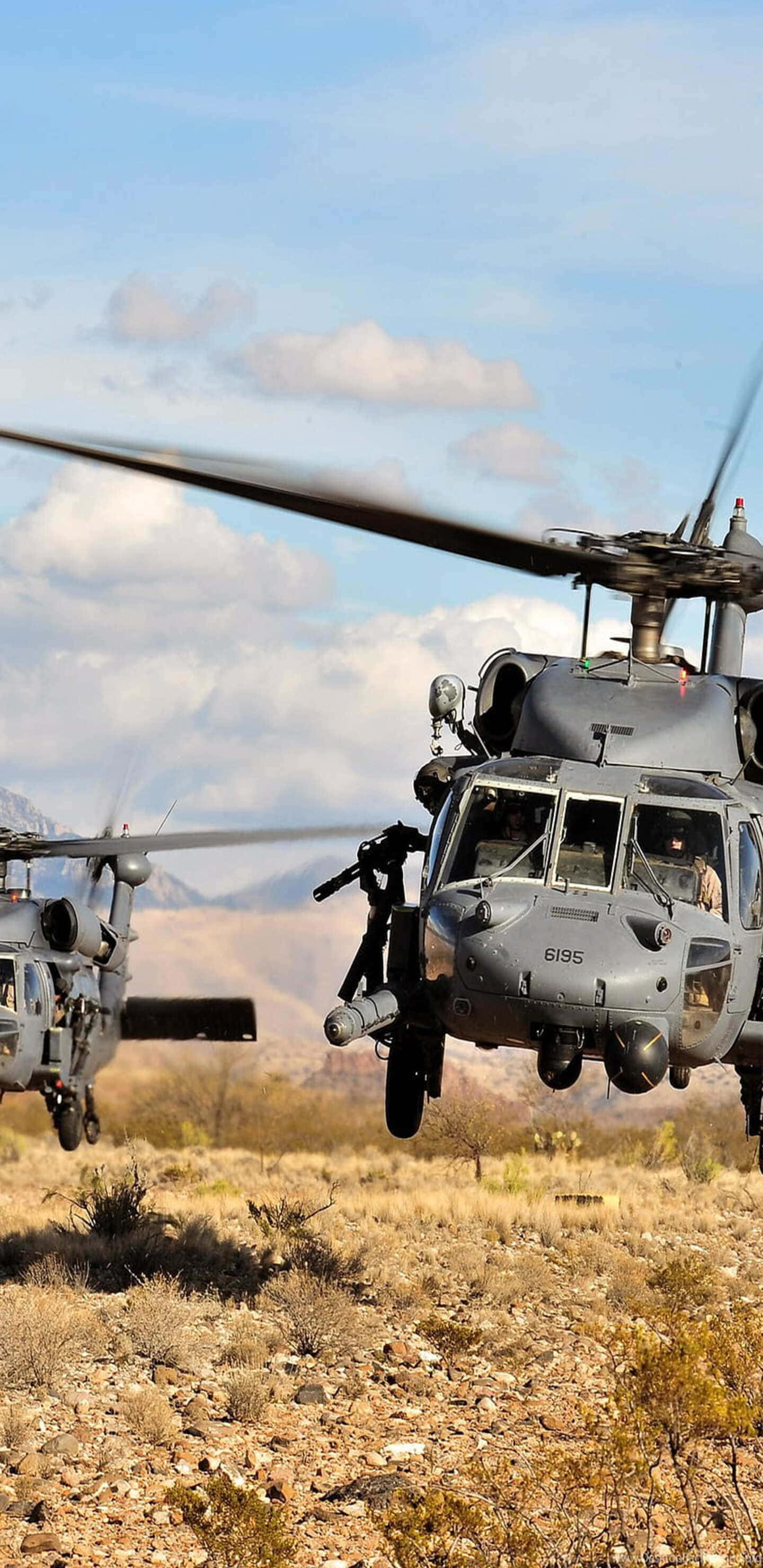 Helicopter 桌布 壁紙 — 兩架軍用直升機在部分多雲的天空下盤旋於乾燥的沙漠景觀之上。