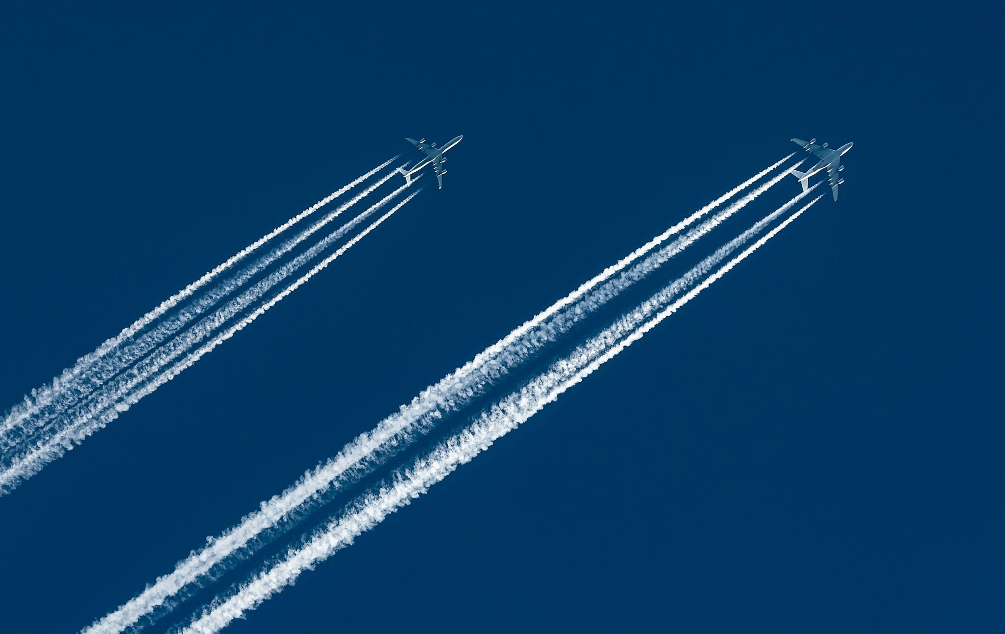 Plane 桌布 壁紙 — 兩架飛機在深藍色的天空中翱翔，留下長長的白色的凝結尾跡。