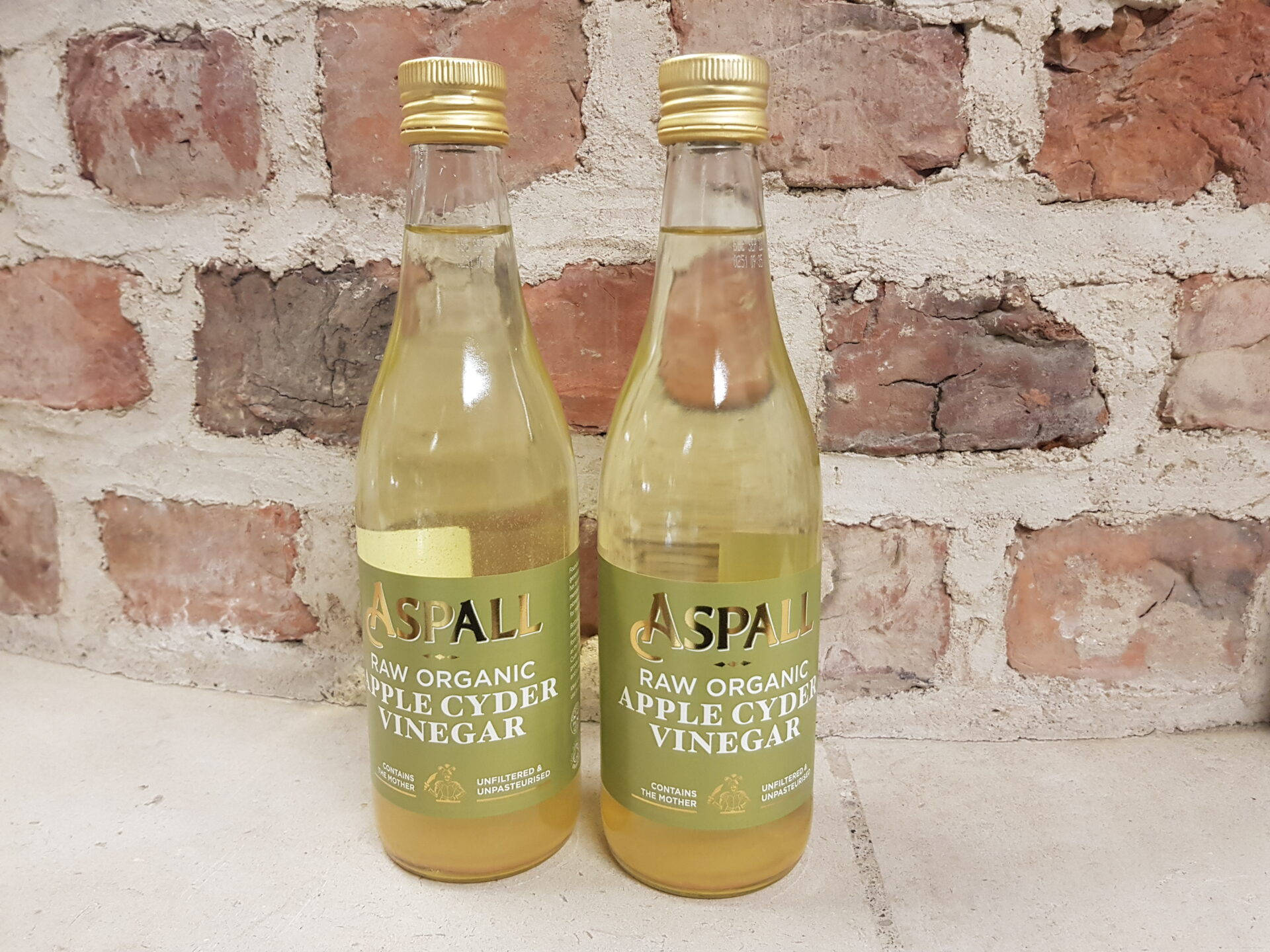 Drink 桌布 壁紙 — 兩瓶Aspall生機有機蘋果醋並排放在質樸的磚牆前。