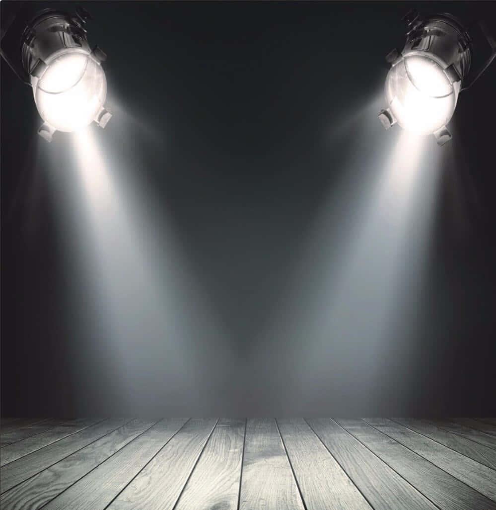 Stage Light 桌布 壁紙 — 兩盞明亮的舞台燈光照射在黑暗空蕩劇院的木地板上。