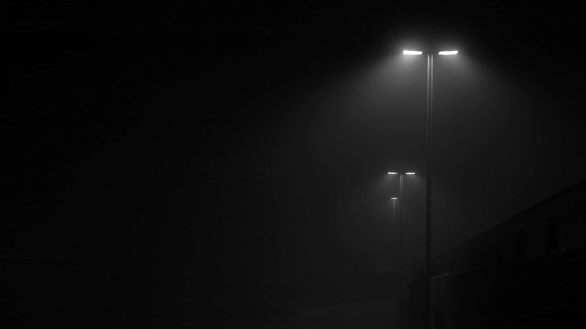 Street Light 桌布 壁紙 — 兩盞街燈在濃霧中穿透黑夜，向漆黑如墨的天空投射出刺眼的白光。