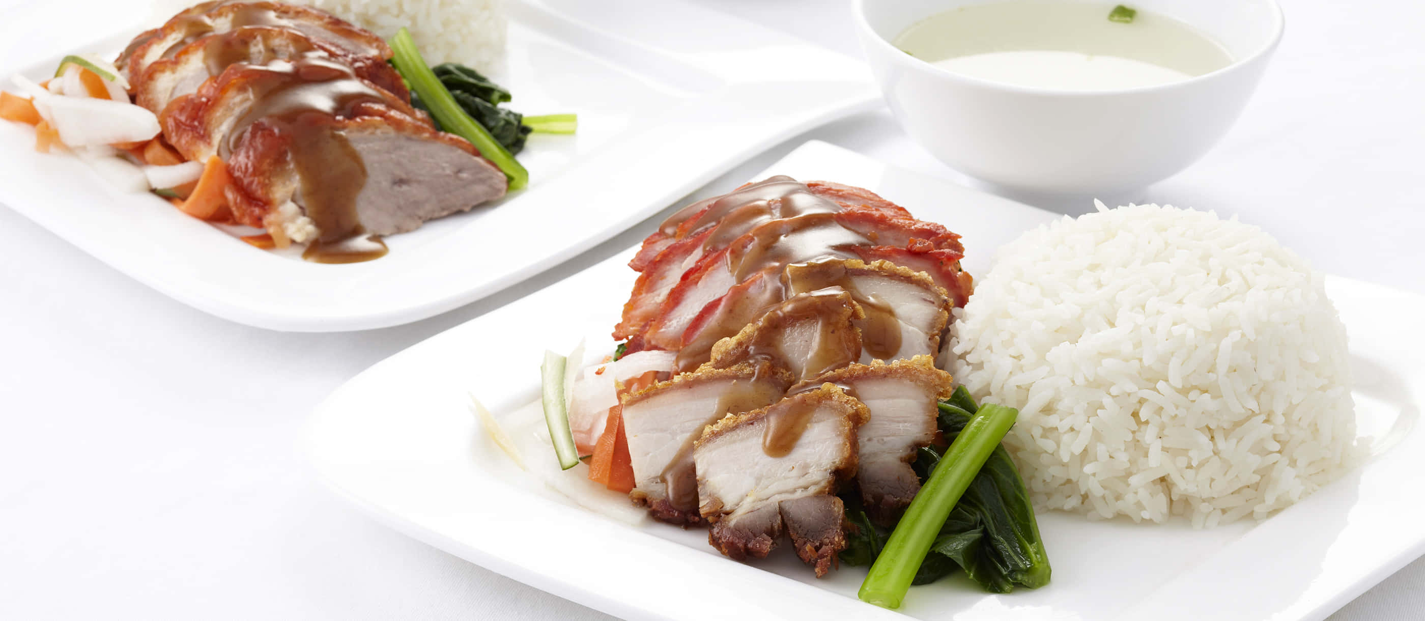 Food Photography 桌布 壁紙 — 兩盤脆皮烤豬肉搭配光澤醬汁和蒸飯，並以青菜點綴。