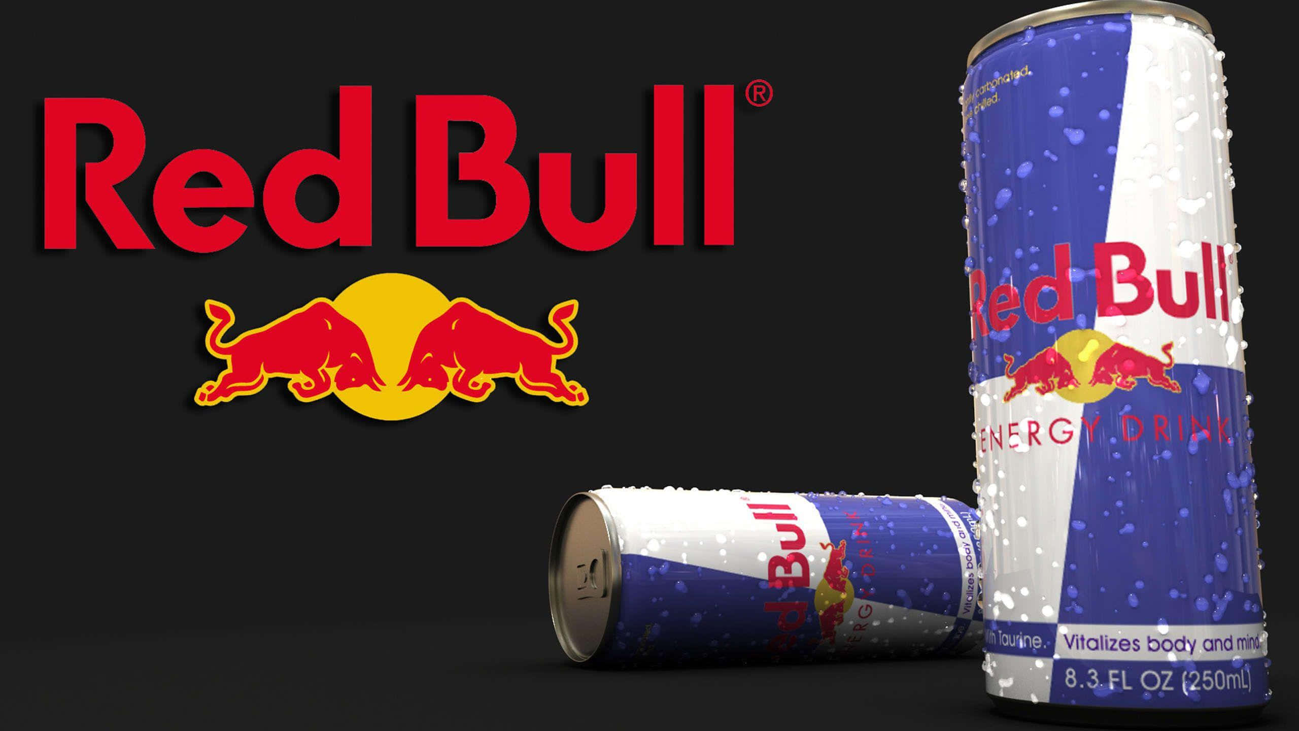 紅牛 桌布 壁紙 — 兩罐Red Bull能量飲料罐，一罐直立一罐平躺，帶冷凝水，黑色背景上展示品牌標誌。