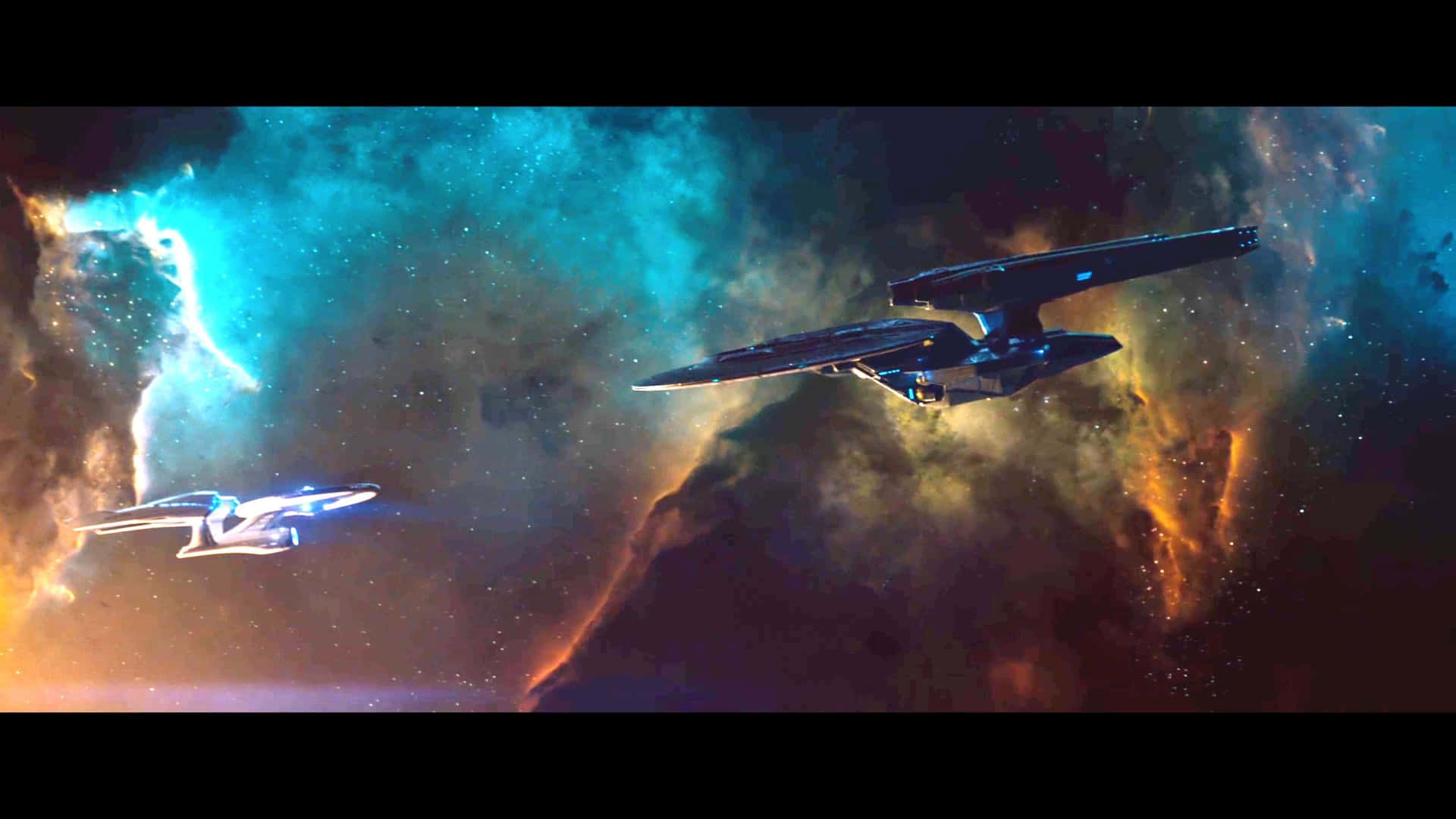 星際爭霸戰 桌布 壁紙 — 兩艘星艦在充滿活力的宇宙星雲中滑行，散發著電光藍和火熱橙色的光芒。