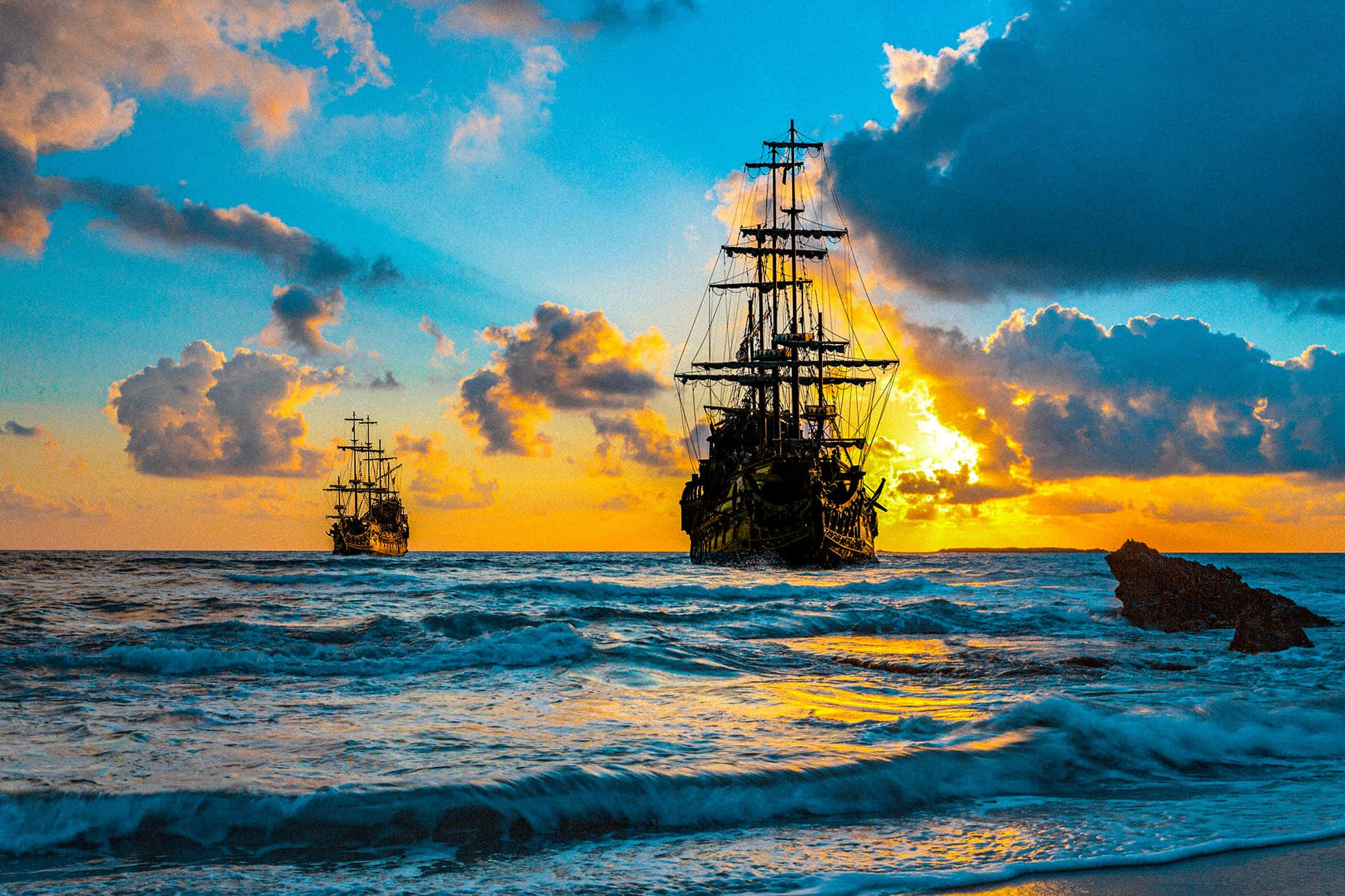 海盜 桌布 壁紙 — 兩艘海盜船在金色雲彩和洶湧波浪的夕陽海上航行。