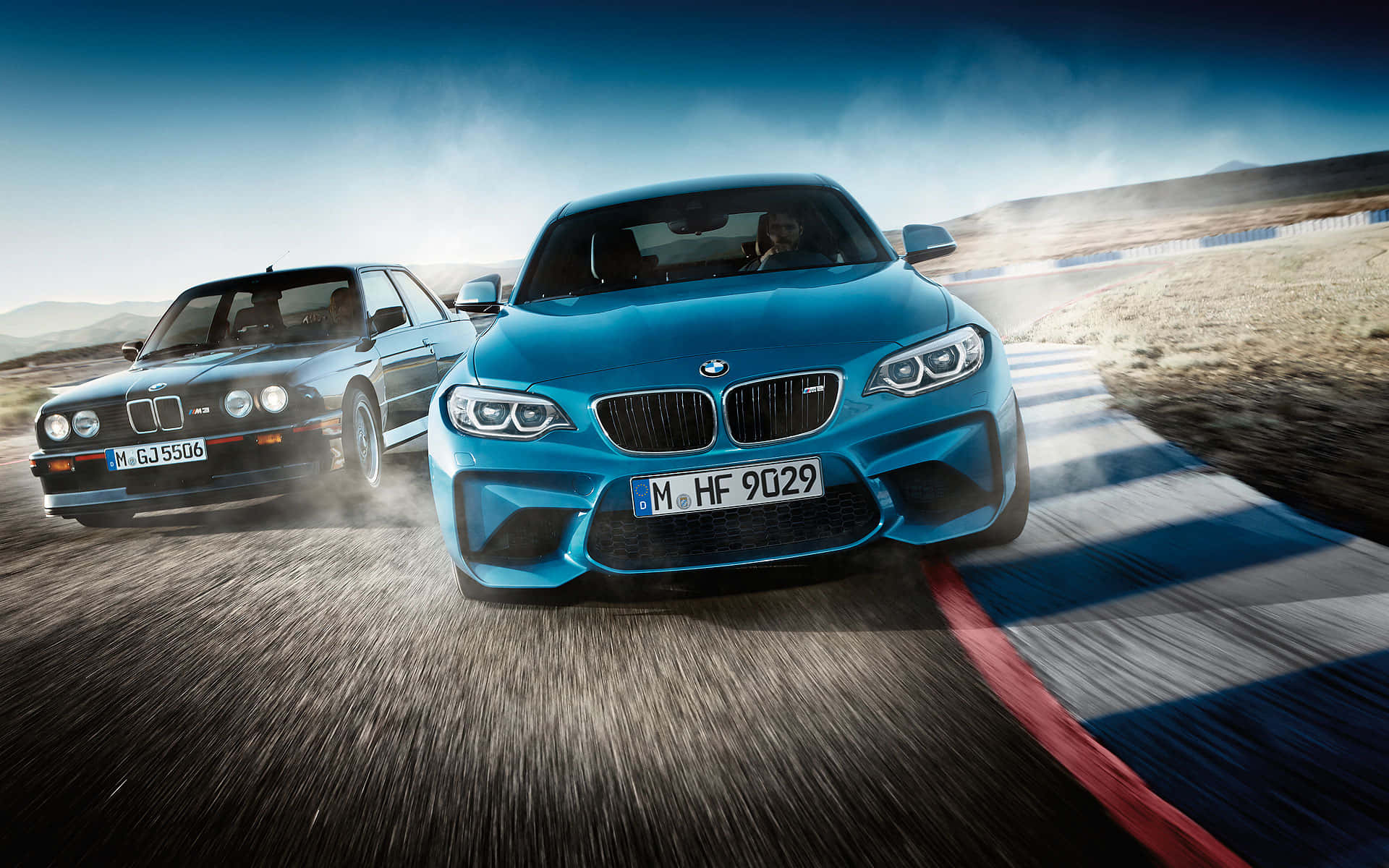 BMW 動圖 桌布 壁紙 — 兩輛BMW在塵土飛揚的賽道上並肩競速，畫面模糊，天空戲劇性。