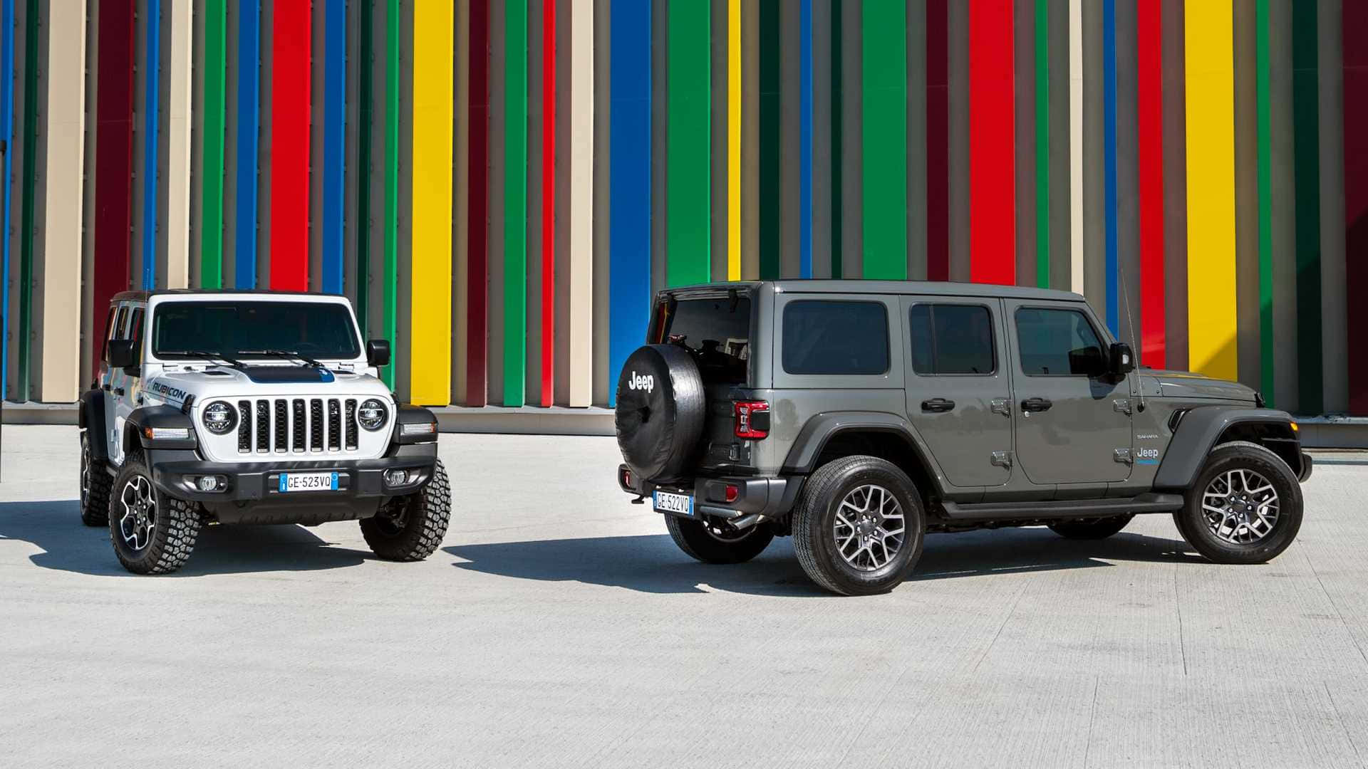 吉普 桌布 壁紙 — 兩輛Jeep Wranglers，一白一灰，停在色彩繽紛的條紋牆前，在明亮的日光下。