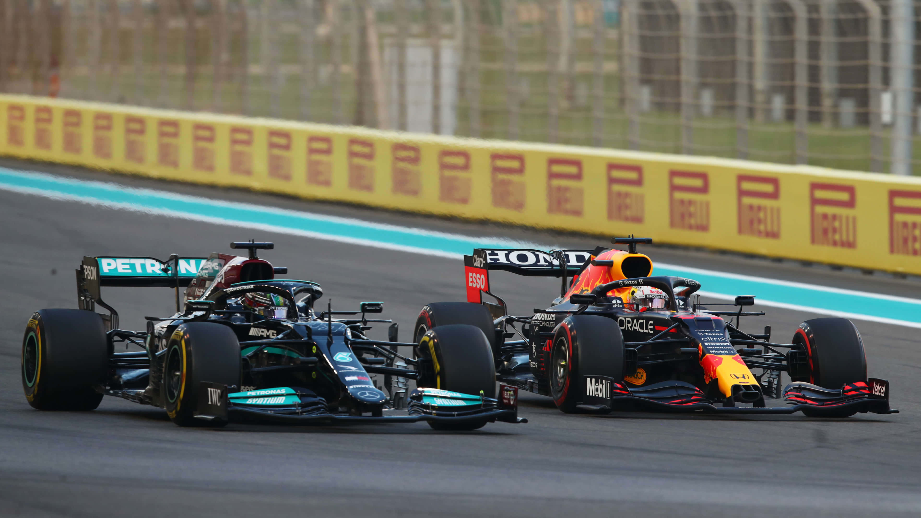 F1 2019 壁紙 桌布 壁紙 — 兩輛一級方程式賽車在賽道上並肩飛馳，背景是黃色的倍耐力護欄。