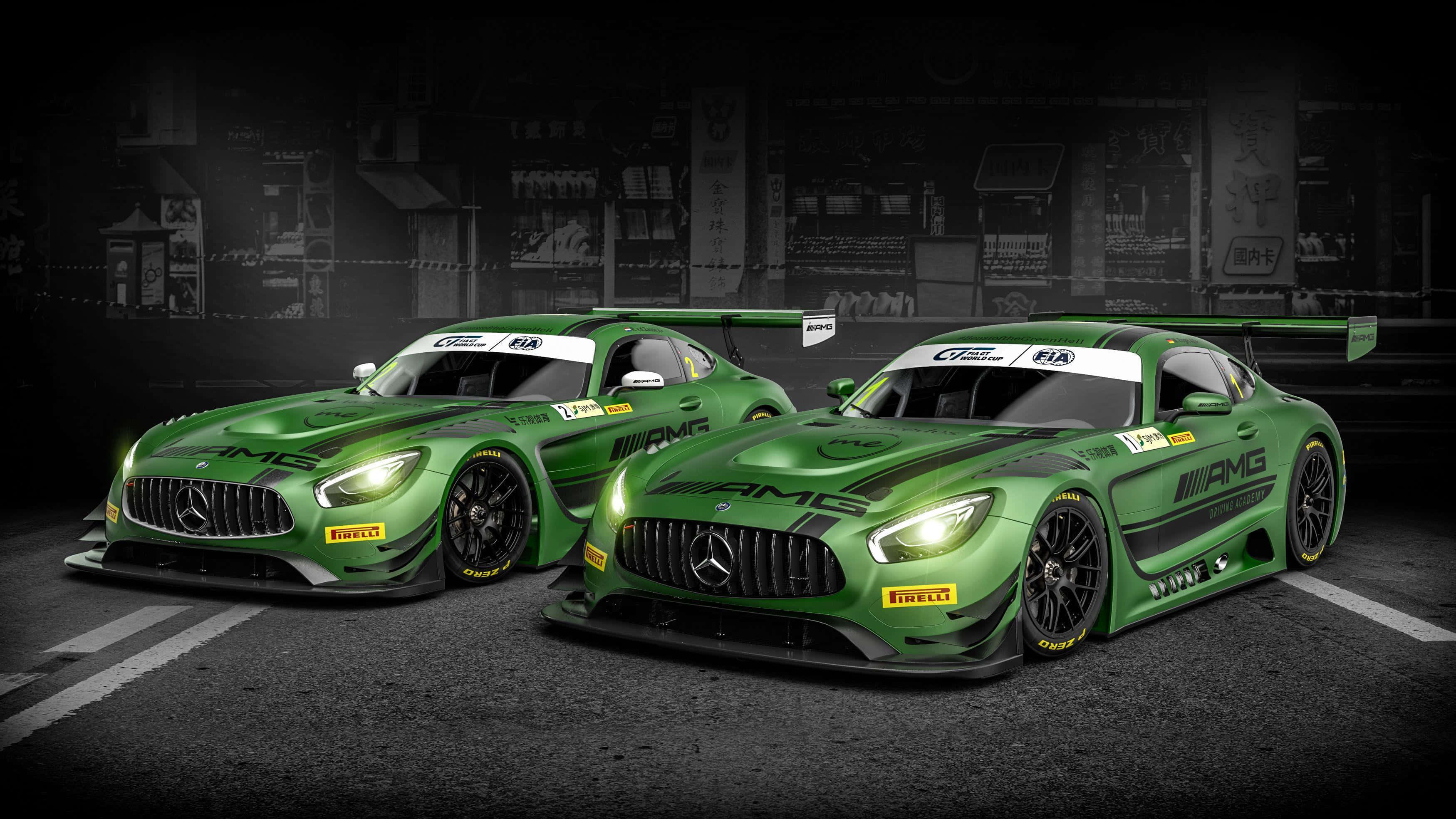 race car 桌布 壁紙 — 兩輛充滿活力的綠色 Mercedes-AMG GT3 賽車，帶有發光的頭燈，停在黑暗的瀝青街道上，背景是模糊的城市景觀。