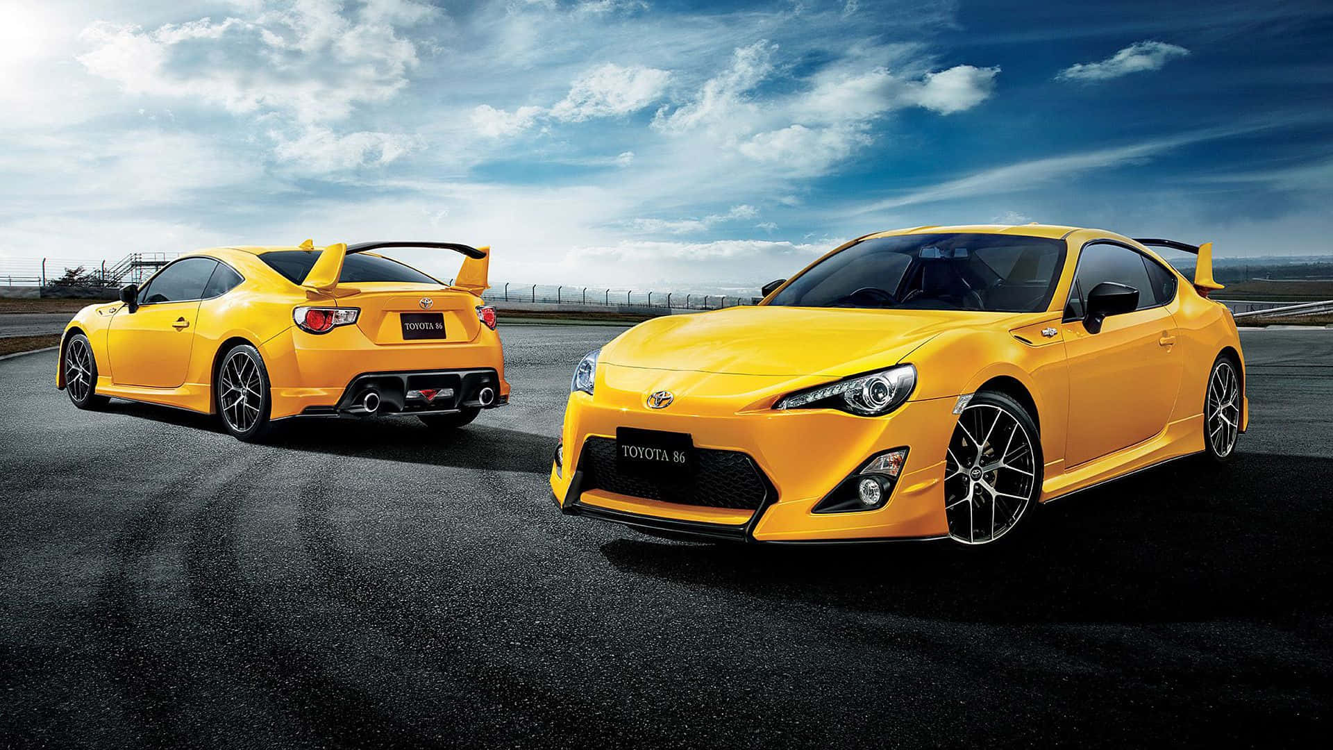 兩輛黃色豐田86跑車在賽道上，天空湛藍。 — Toyota Supra Mk4 壁紙