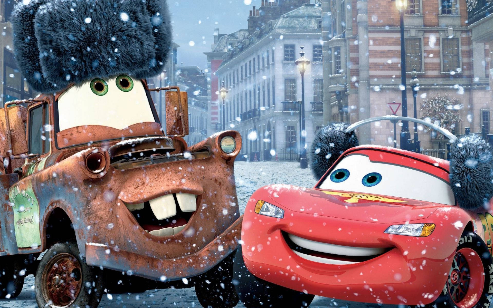 cars 桌布 壁紙 — 兩輛戴著毛茸茸冬帽的開心動畫車在積雪的歐洲城市街道上微笑。