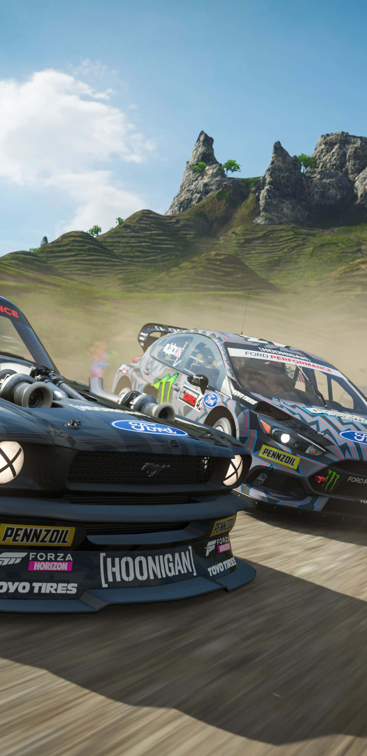 Pixel 3xl Forza Horizon 4 桌布 壁紙 — 兩輛拉力賽車在塵土飛揚的山路上激烈競速，周圍是岩石山峰和綠色山丘，天空湛藍明亮。