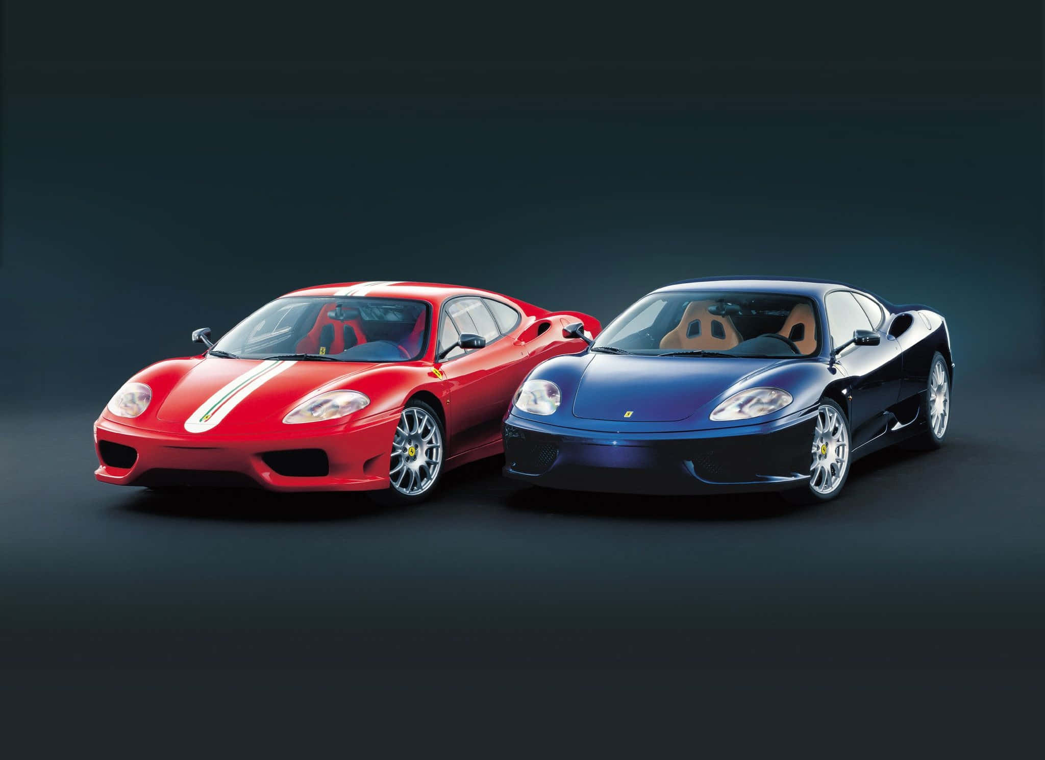 Ferrari 360 Modena 桌布 壁紙 — 兩輛時尚的法拉利跑車，一輛紅色帶白色條紋，一輛深藍色，在深色攝影棚背景下擺姿勢。