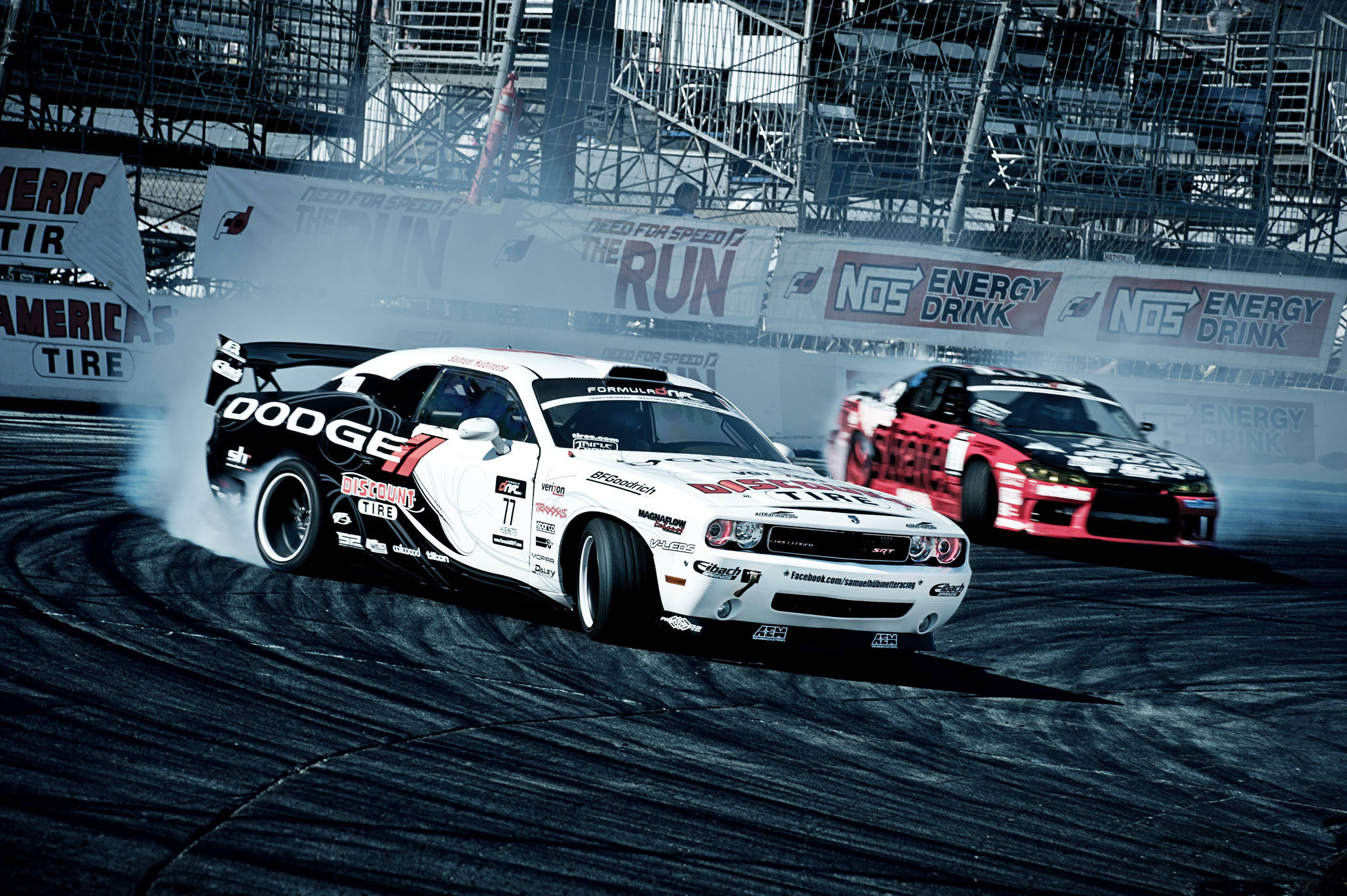 drifting 桌布 壁紙 — 兩輛漂移賽車在潮濕的賽道上側滑，在明亮的體育場燈光下揚起煙霧。