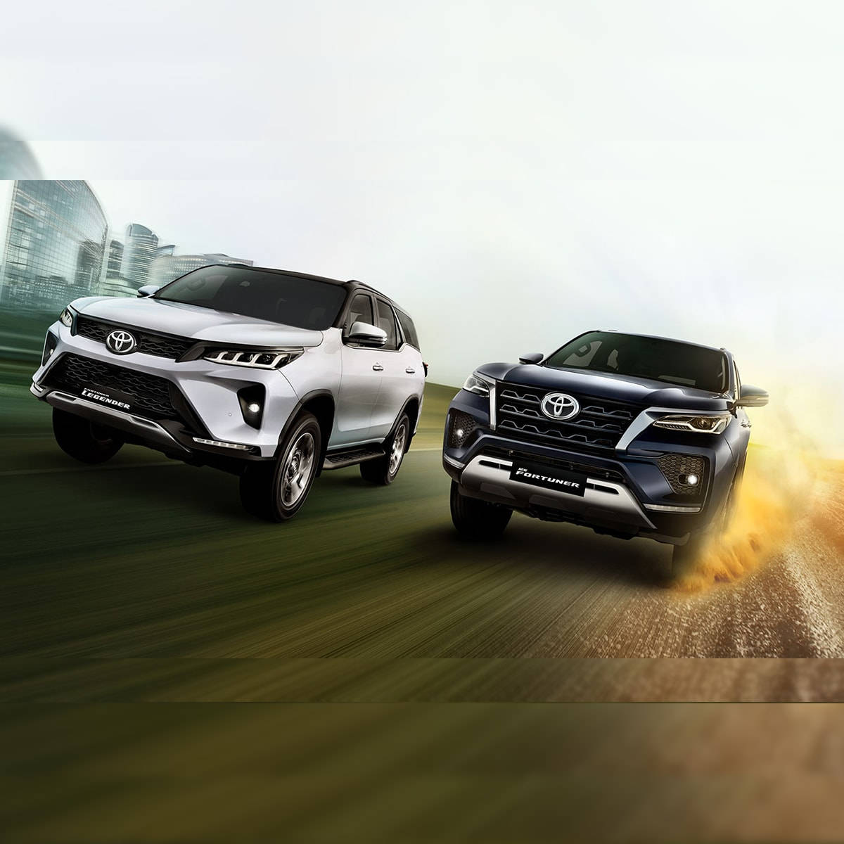 Toyota 桌布 壁紙 — 兩輛現代SUV在道路上並排競速，背景為模糊的城市景觀和動態模糊效果。