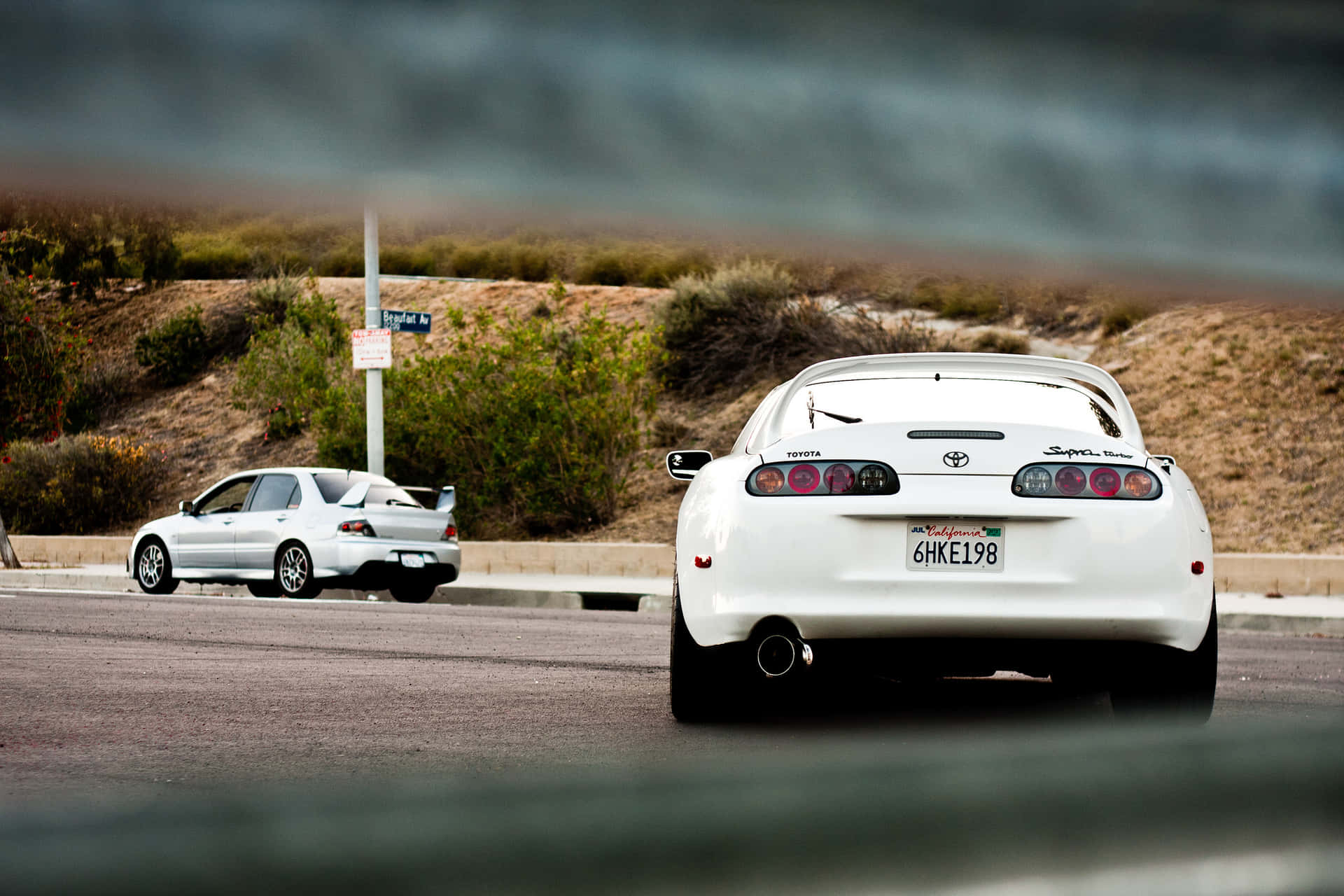 兩輛白色跑車在黃昏的沙漠公路上飛馳。 — Toyota Supra Mk4 壁紙